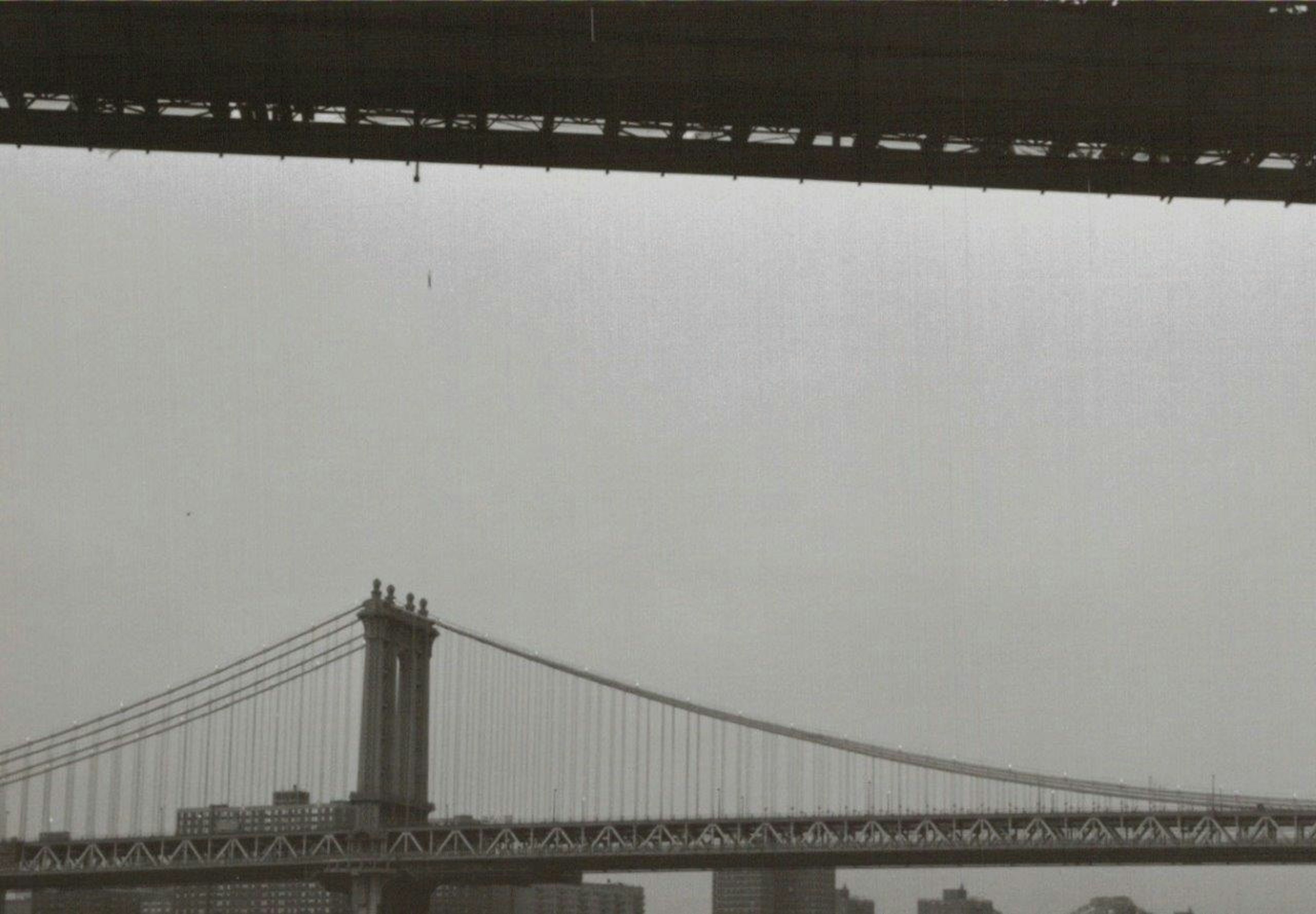 Foto en blanco y negro del puente de Manhattan bajo un cielo nublado