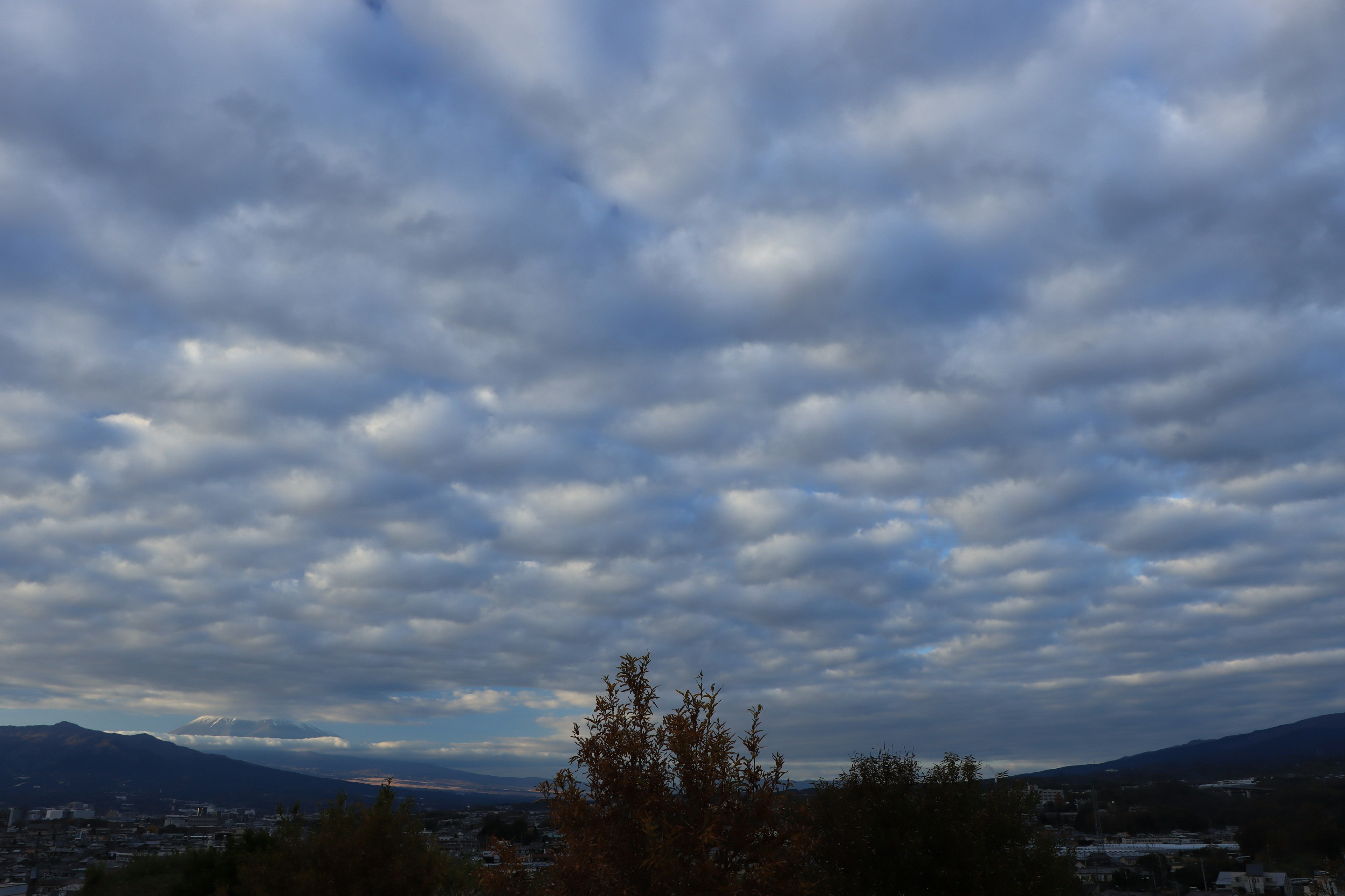 Weitläufiger Himmel voller Wolken und entfernten Bergen