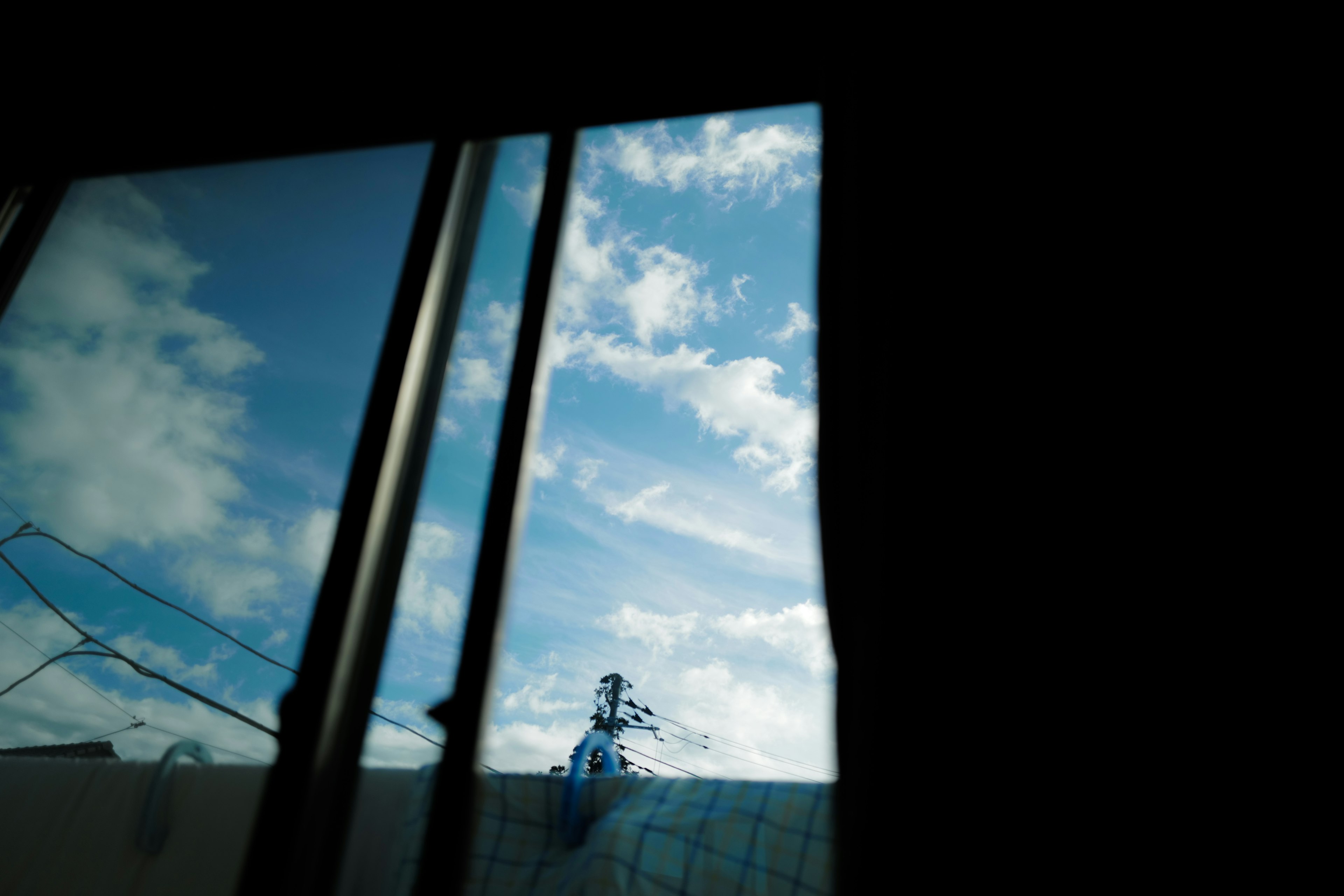 Blick auf den blauen Himmel und die Wolken von einem Fenster