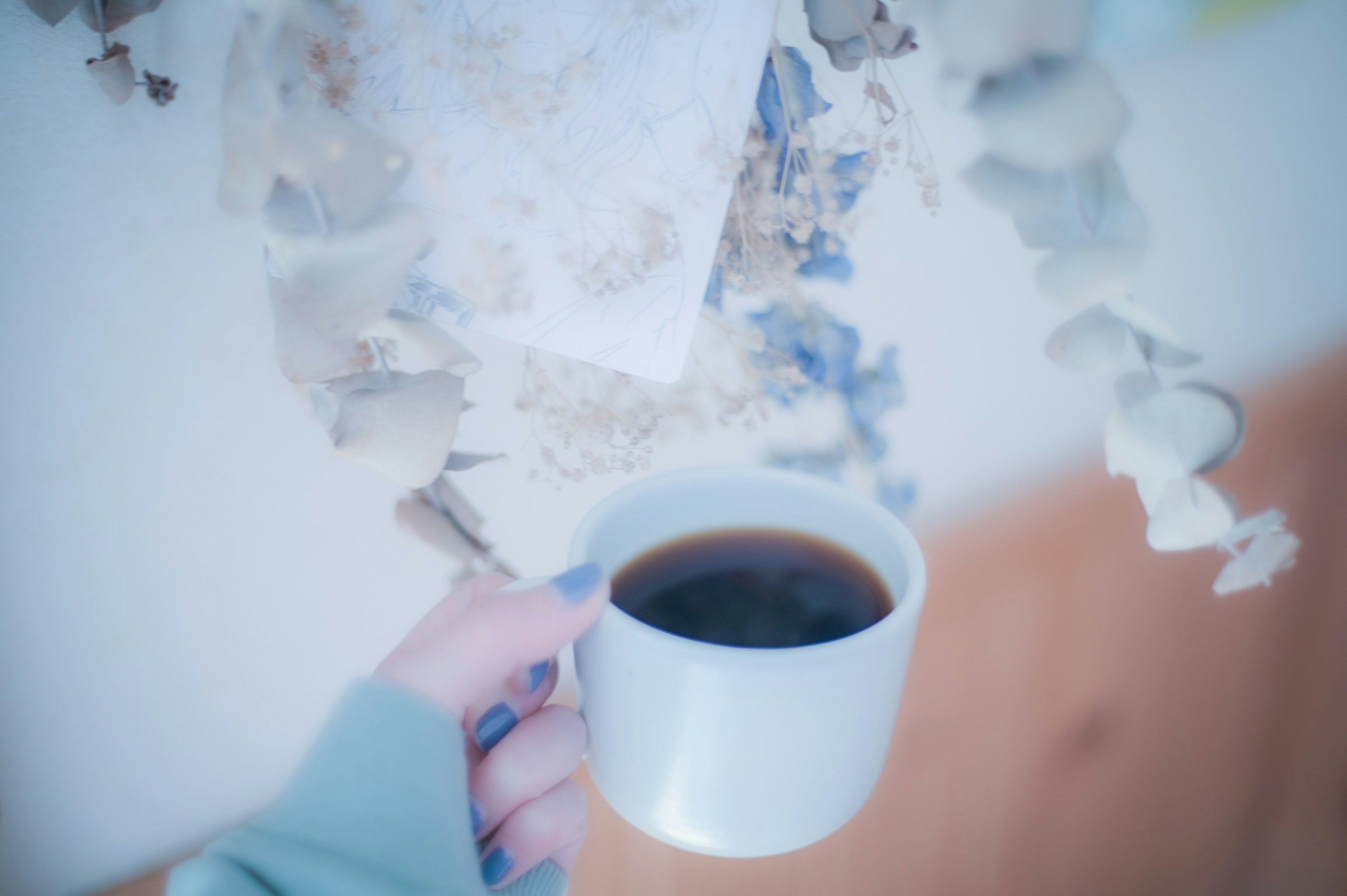 Immagine di una mano che tiene una tazza di caffè bianca