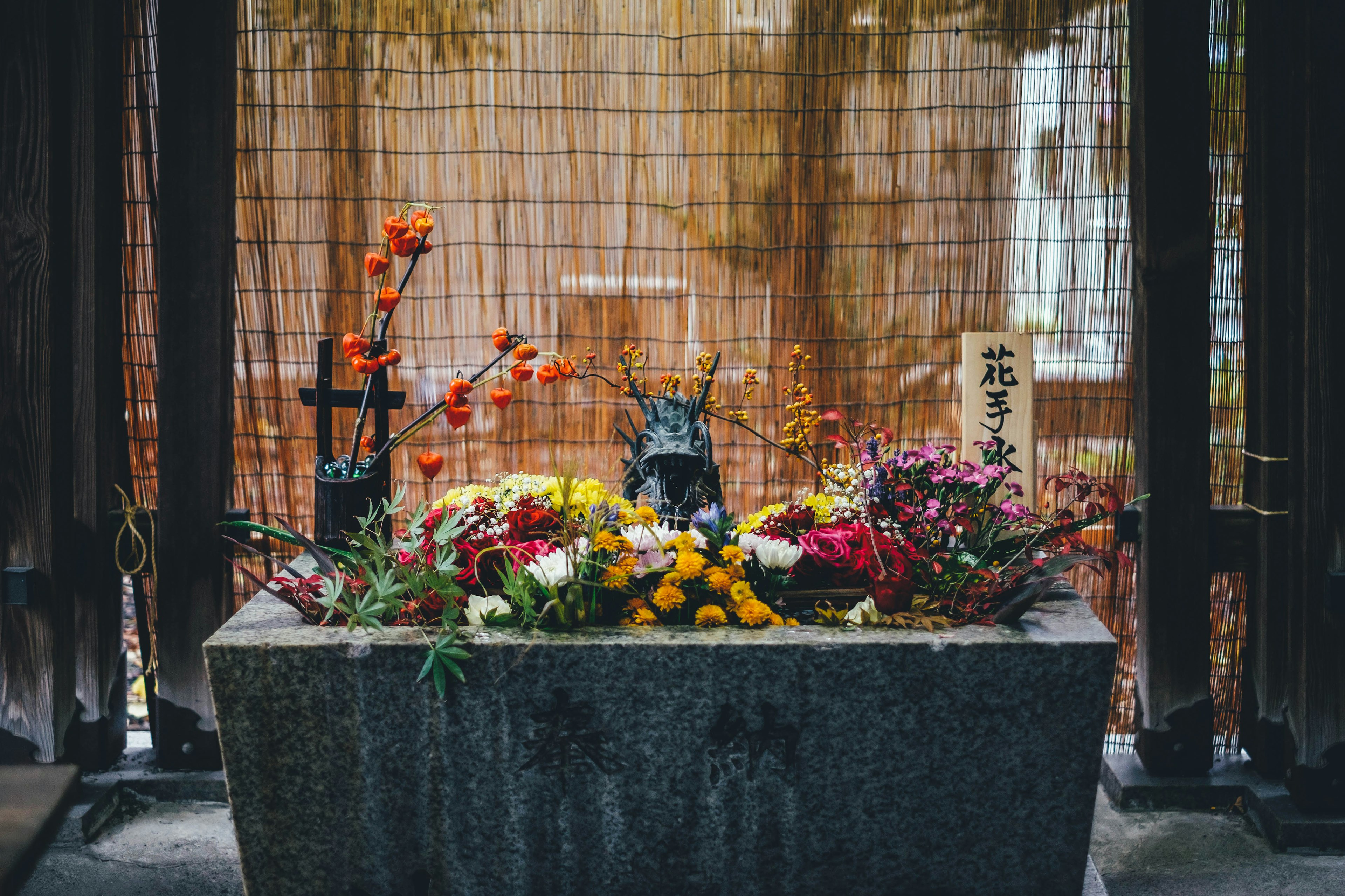 Altar de piedra adornado con flores y fondo de malla metálica