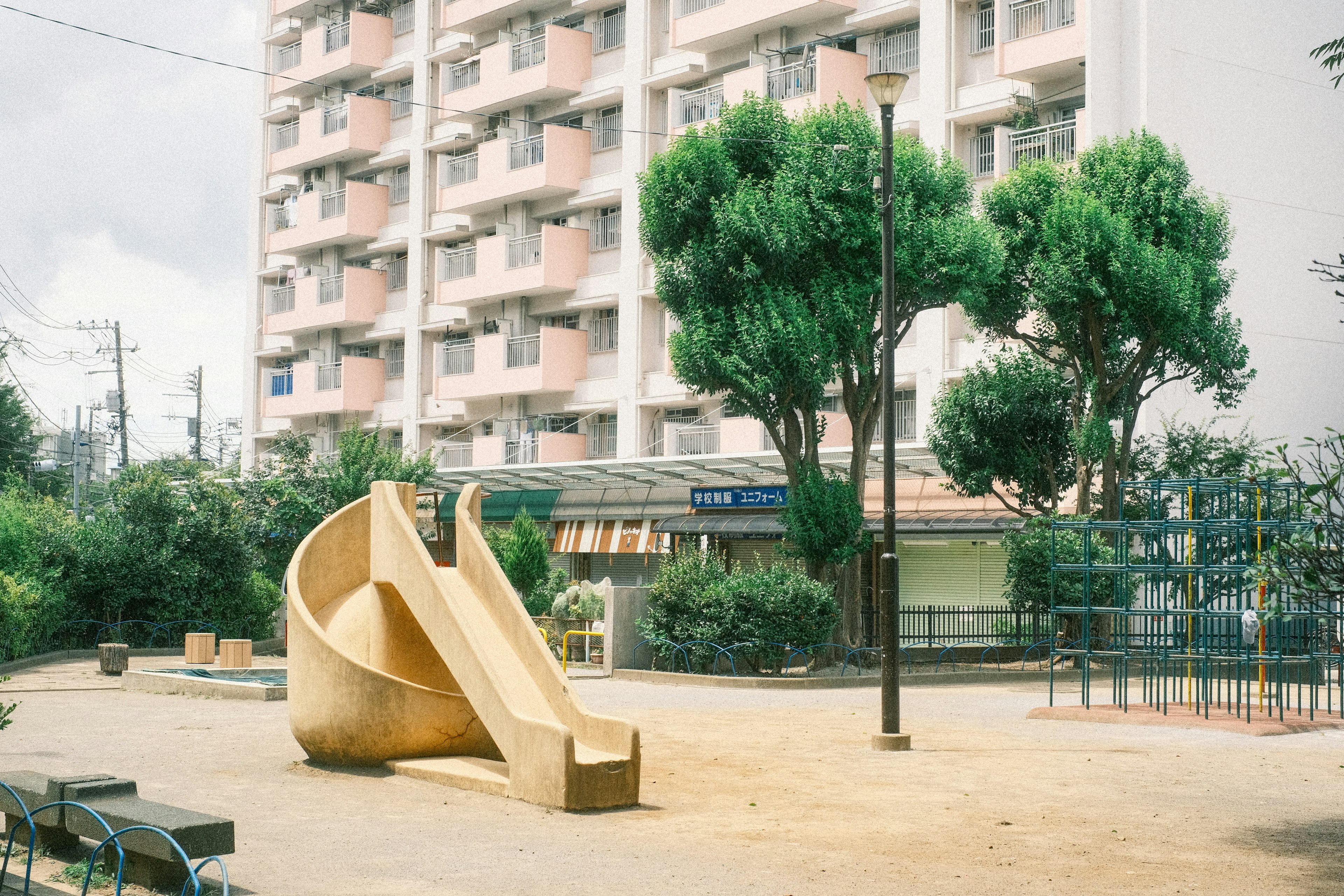 公園の滑り台と周囲の木々がある風景