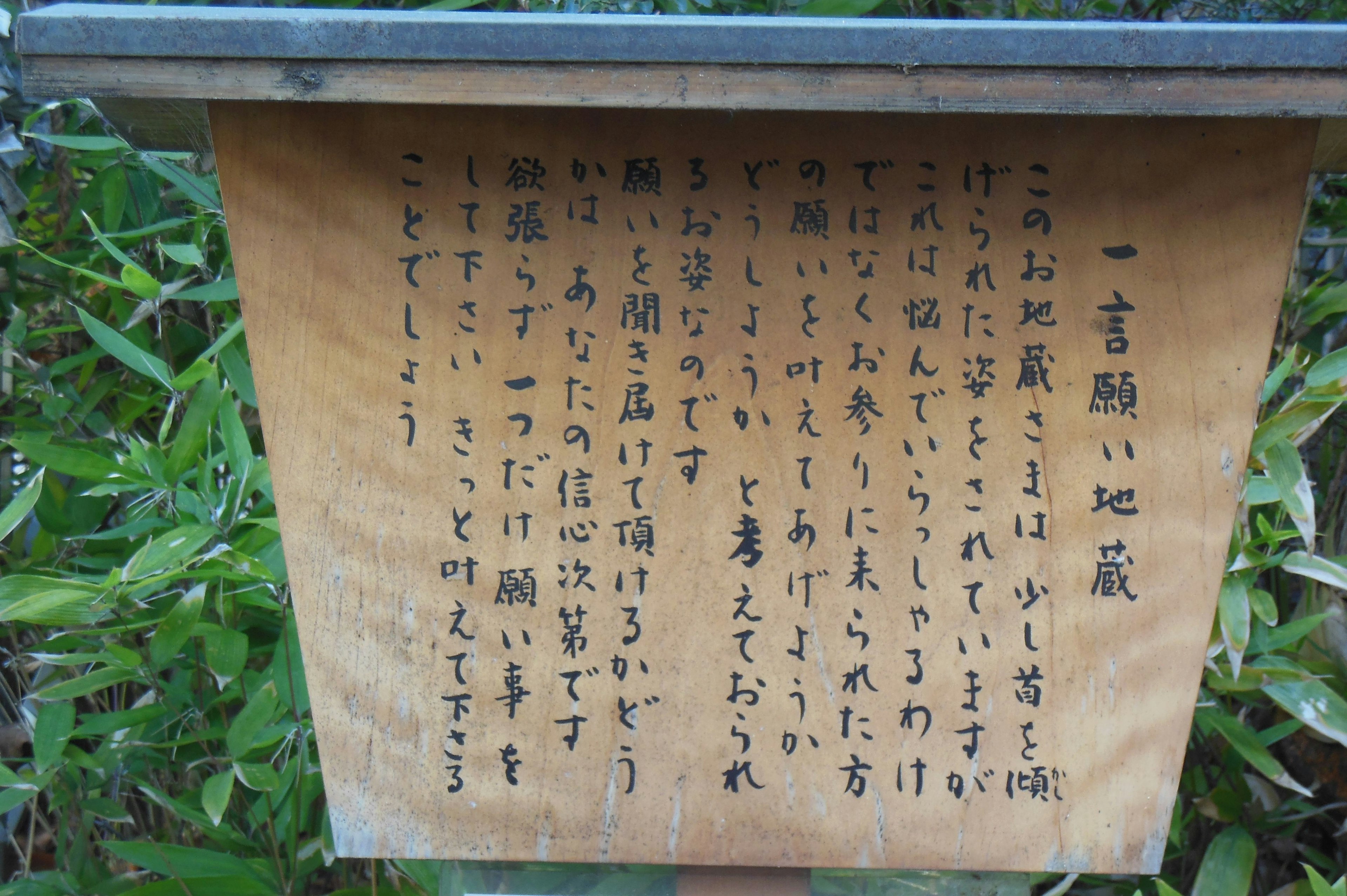 木製の看板に書かれた日本語の文章が見える