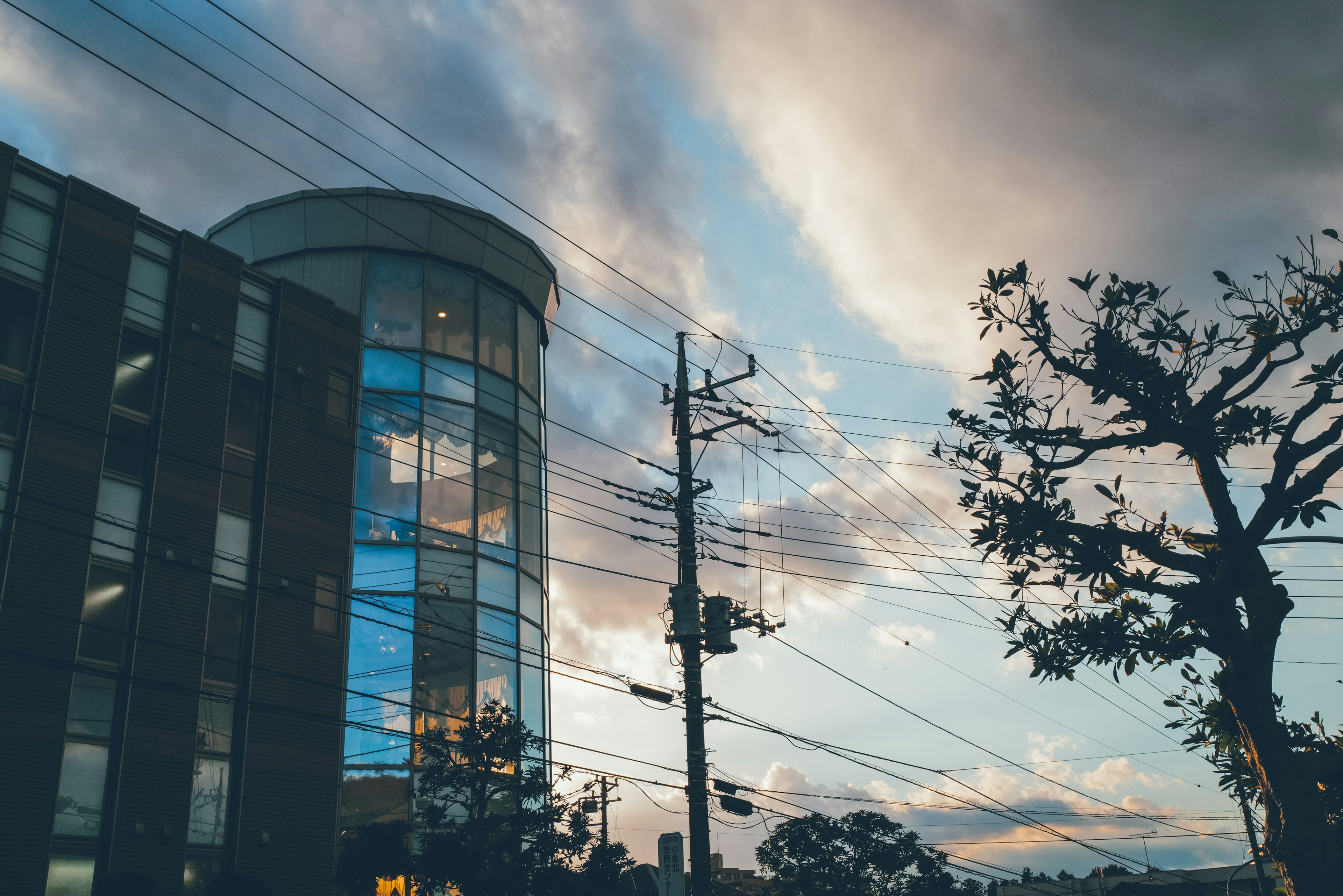 Silueta de un edificio y un árbol contra un cielo colorido al atardecer