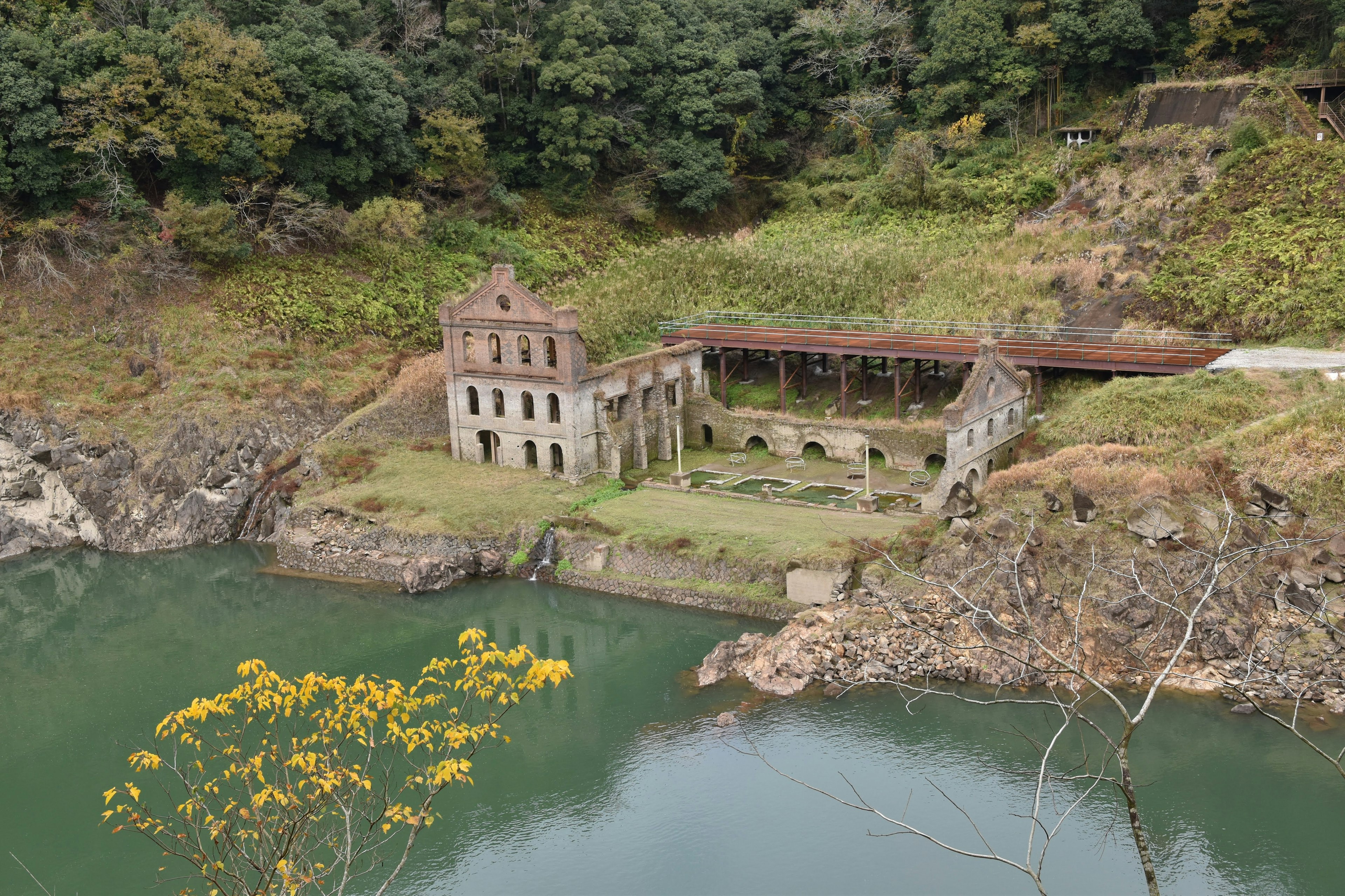 一個寧靜的水邊場景，帶有一座廢棄的建築