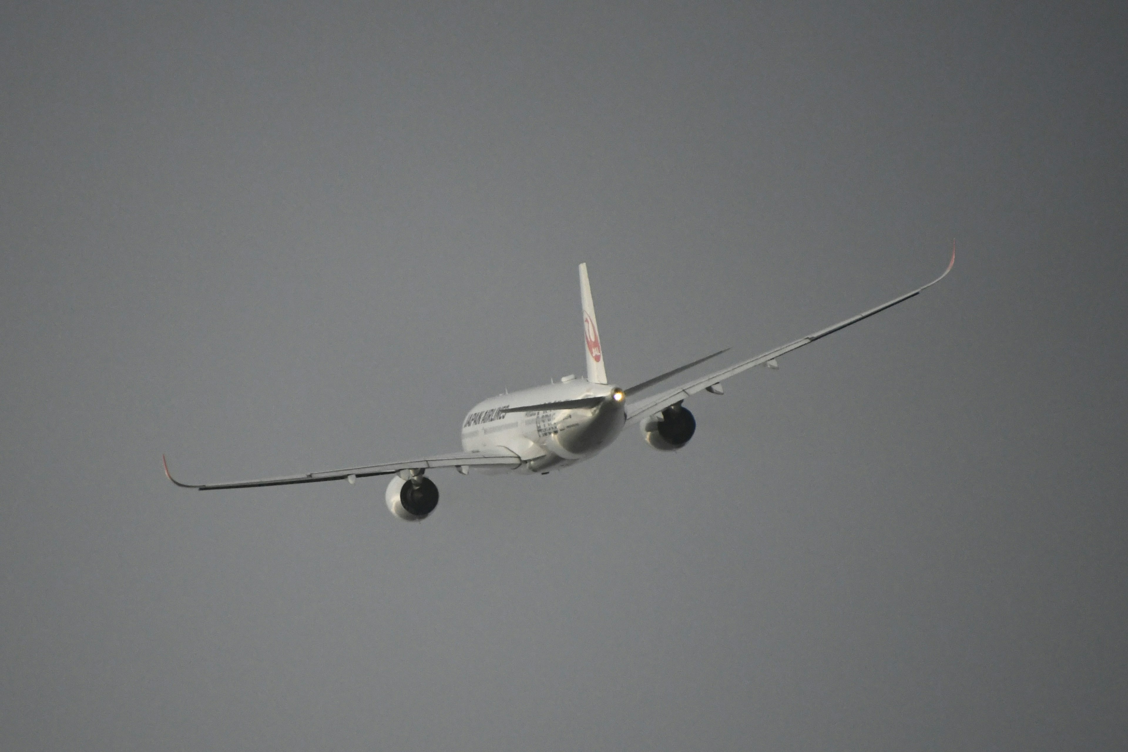 Avion volant loin du spectateur avec un fond nuageux