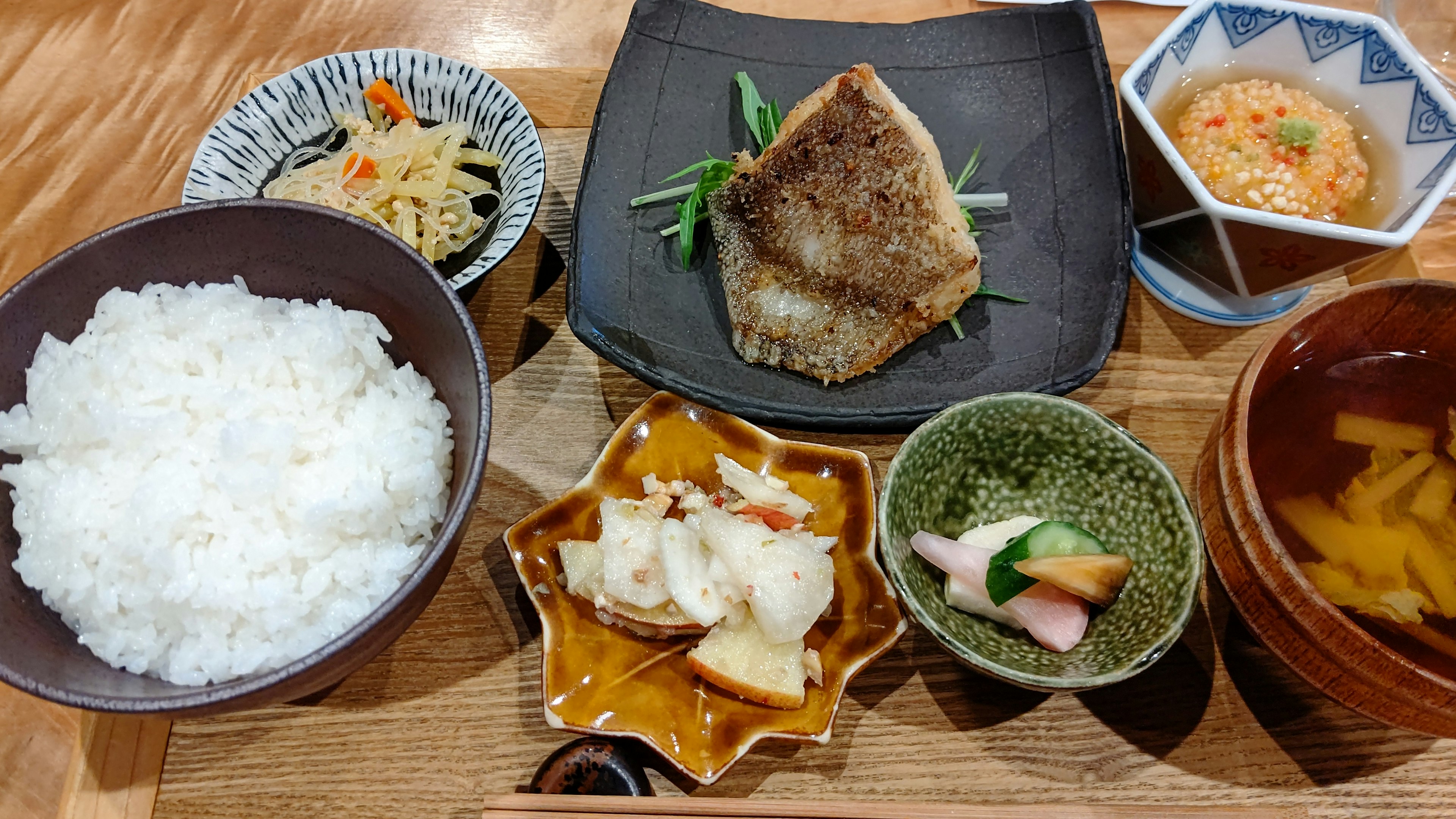 Japanisches Essen mit weißem Reis gegrilltem Fisch und verschiedenen Beilagen