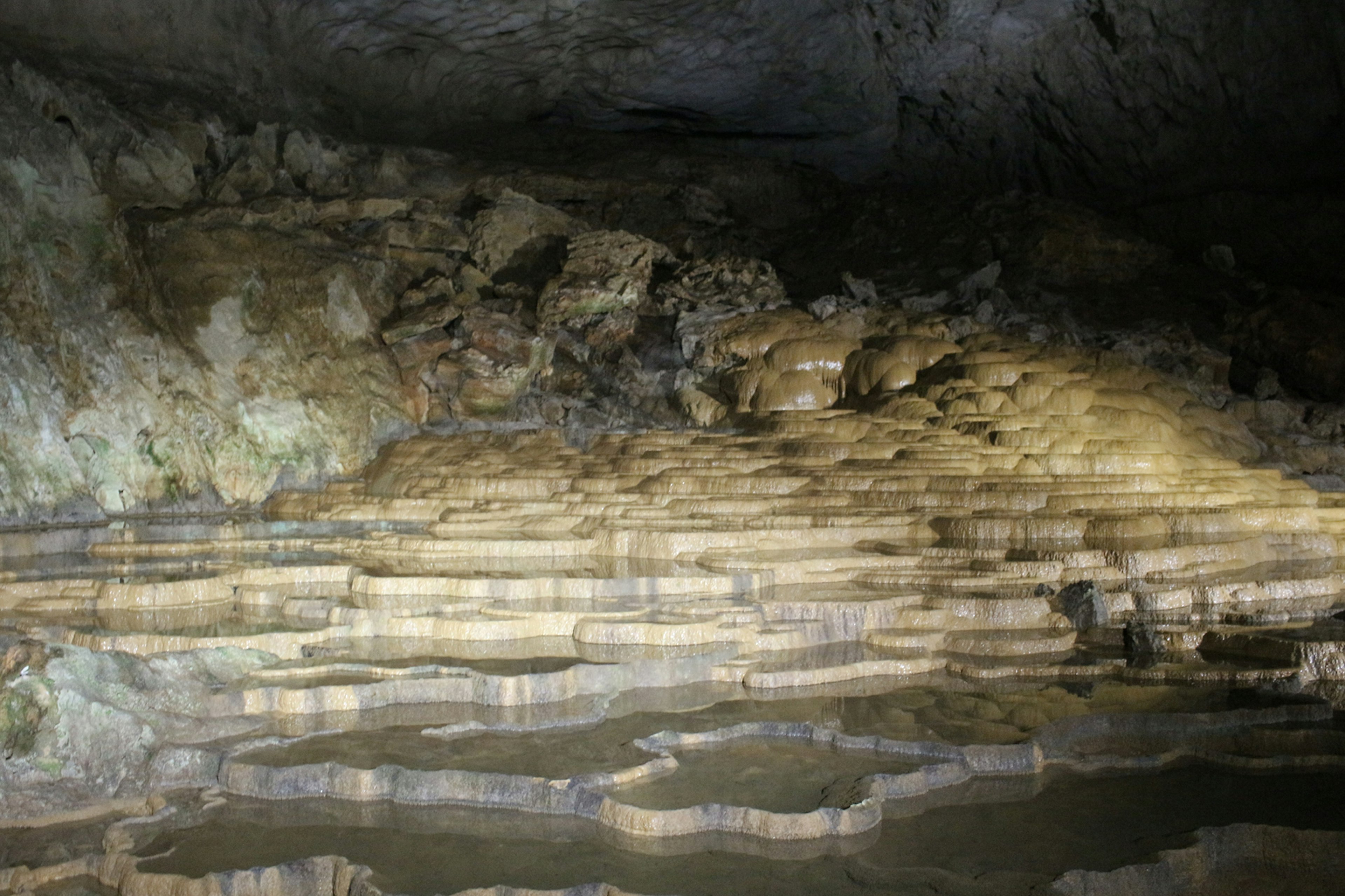 Intérieur de caverne mystérieuse avec stalagmites et mares d'eau