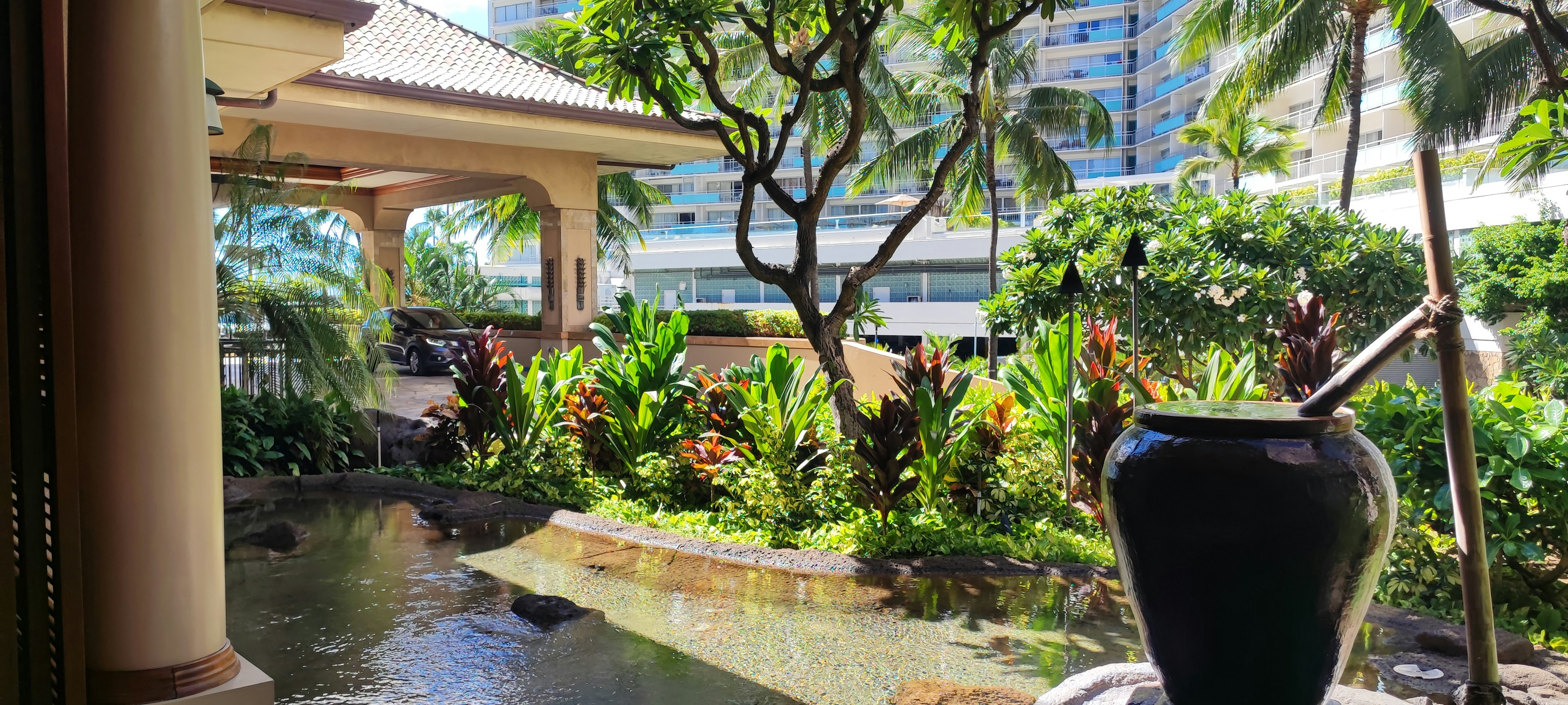 Scenic view of a resort garden with a pond and tropical plants