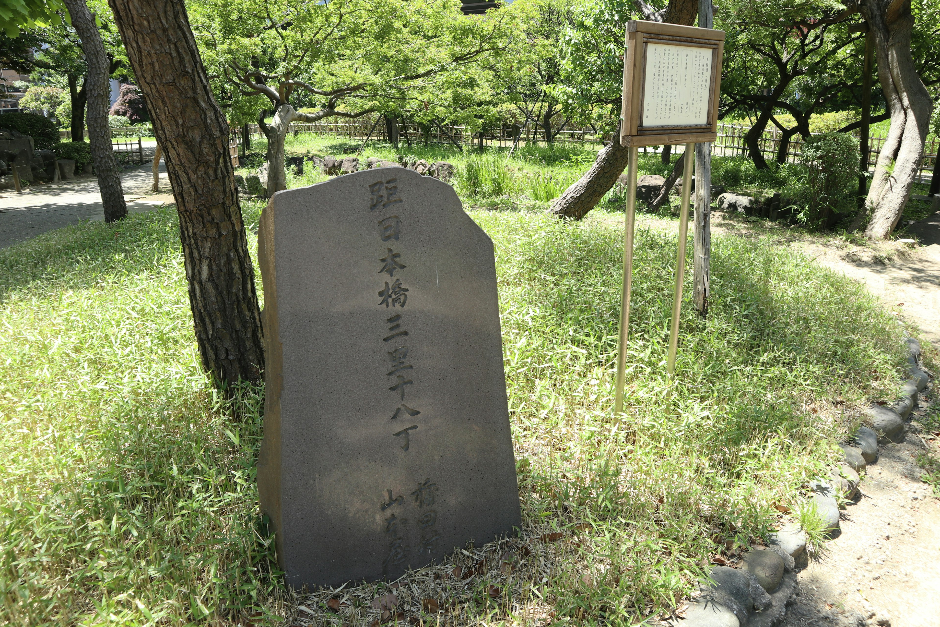 Un monumento in pietra circondato da vegetazione in un parco sereno