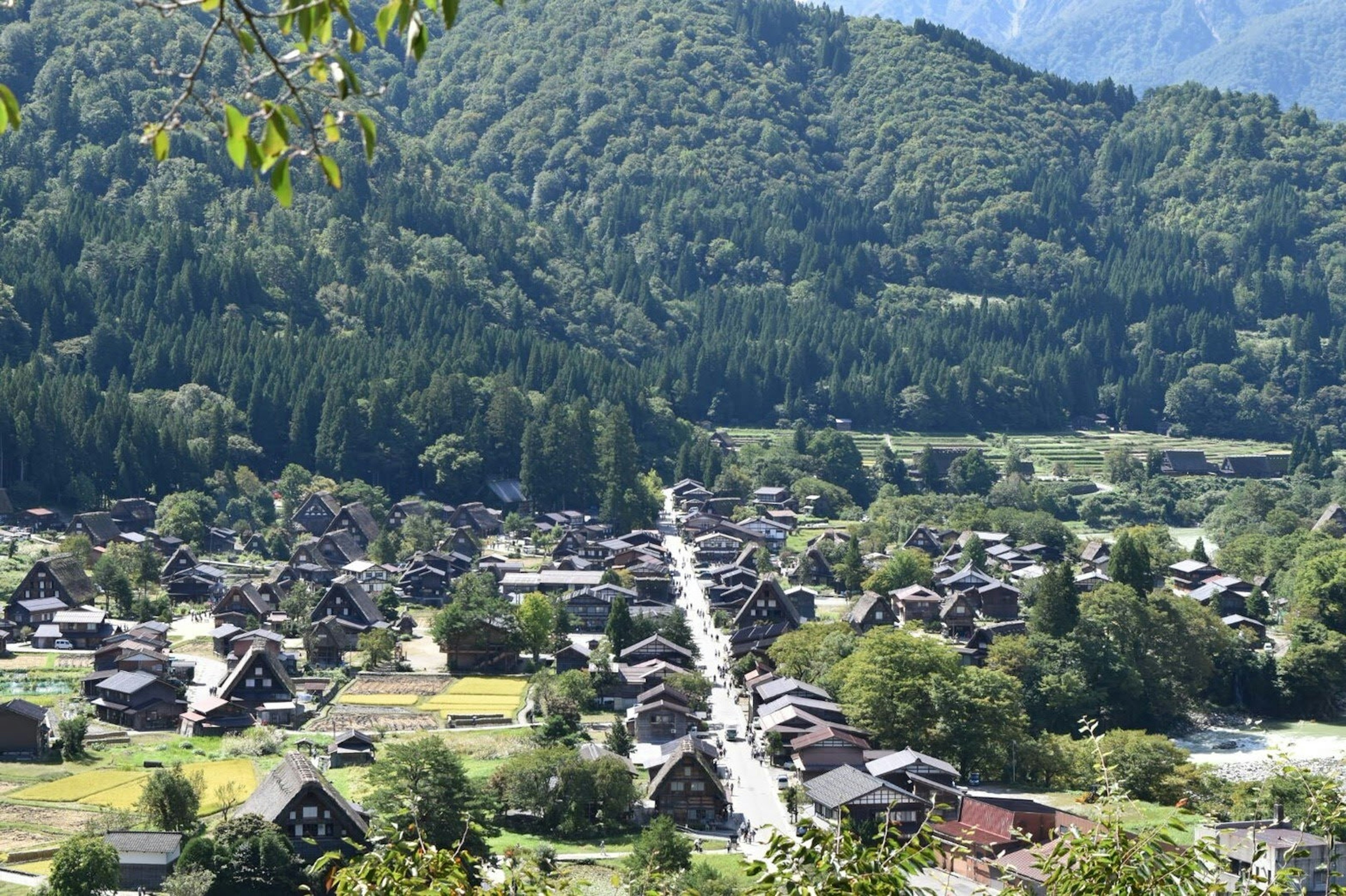 A scenic view of a traditional Japanese village surrounded by mountains