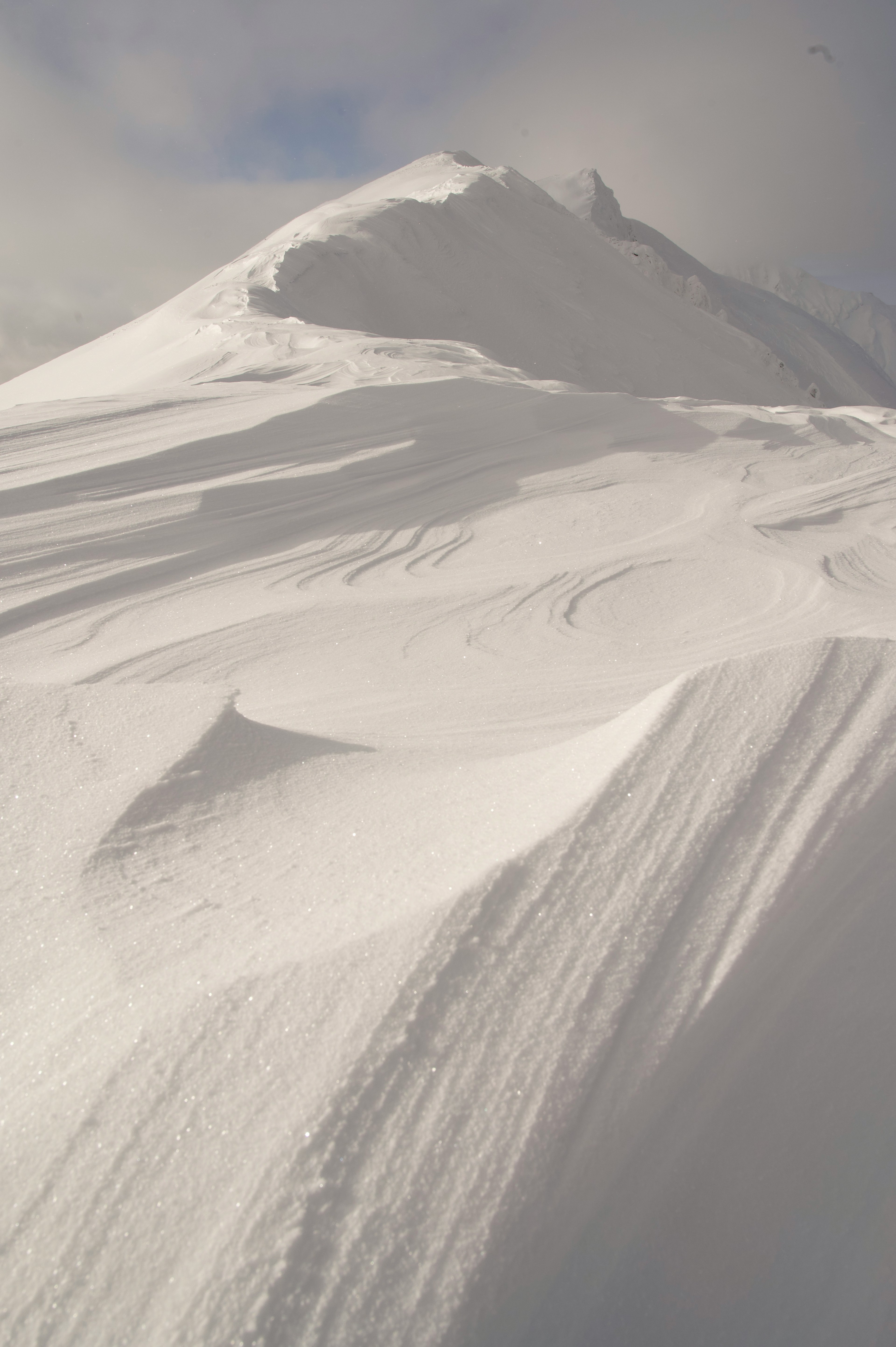 Schneebedeckte Berglandschaft mit glatten Schneeverwehungen