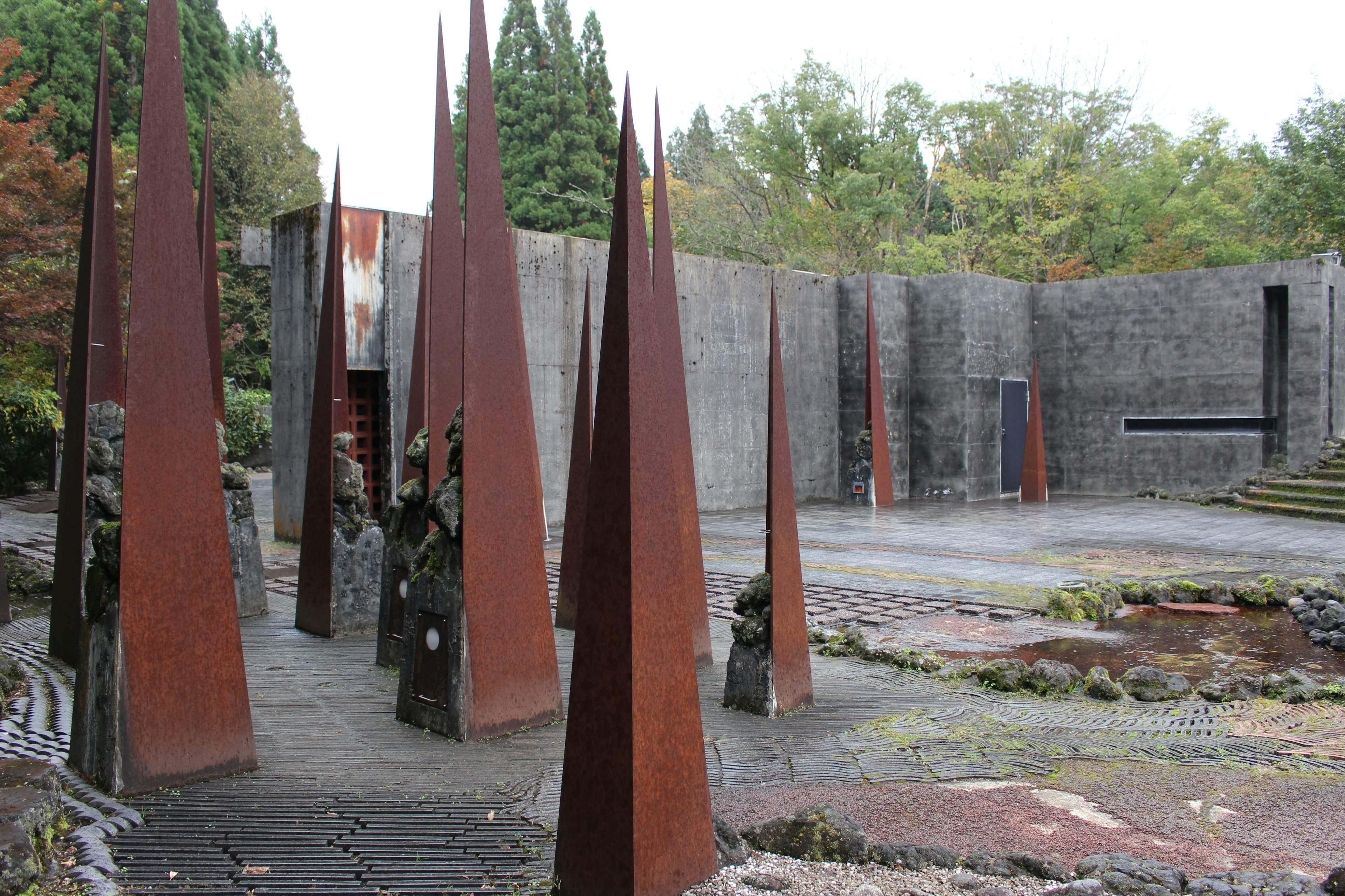 Rusty spires in a concrete space surrounded by greenery