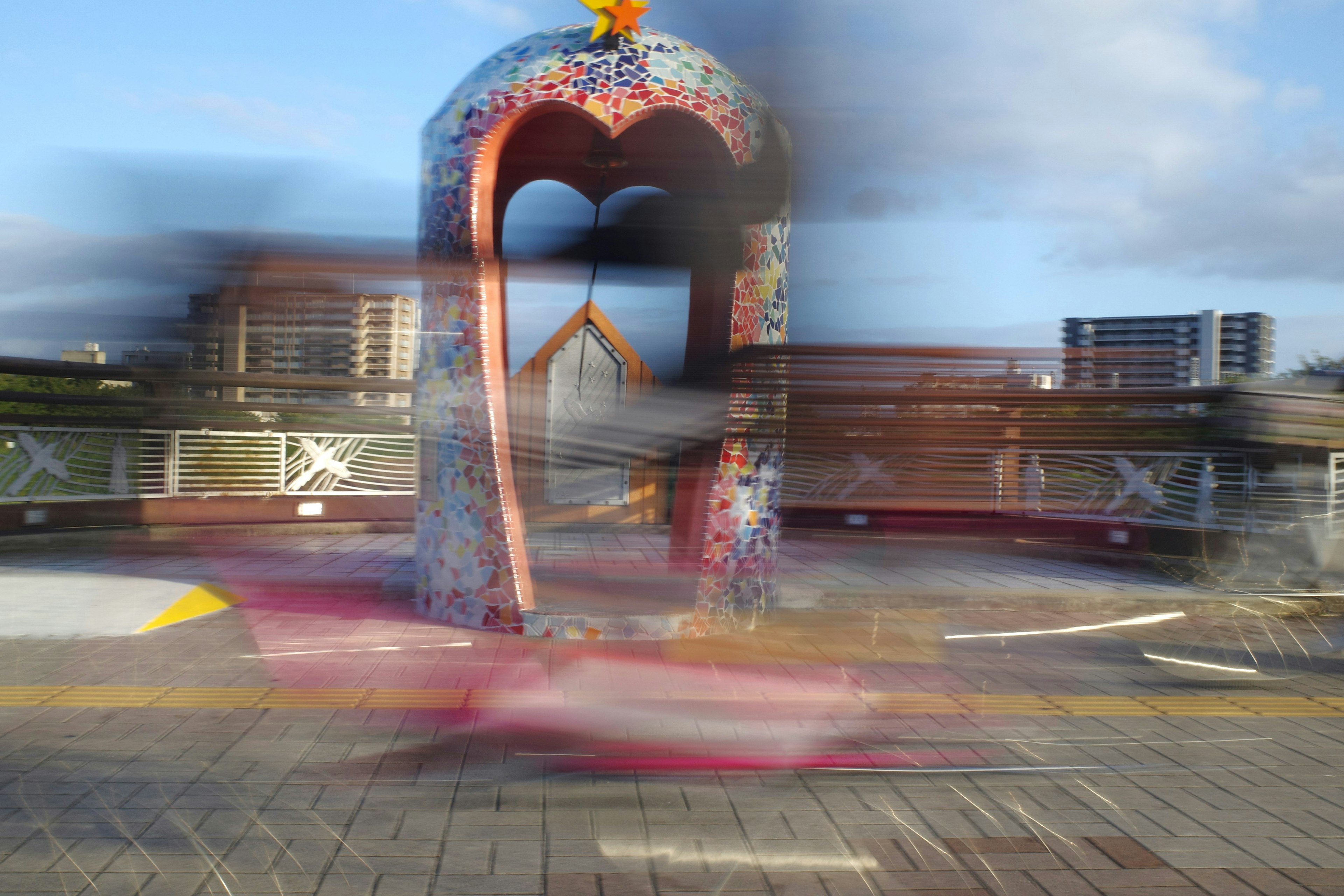 Colorful monument with blurred passing cars in urban setting