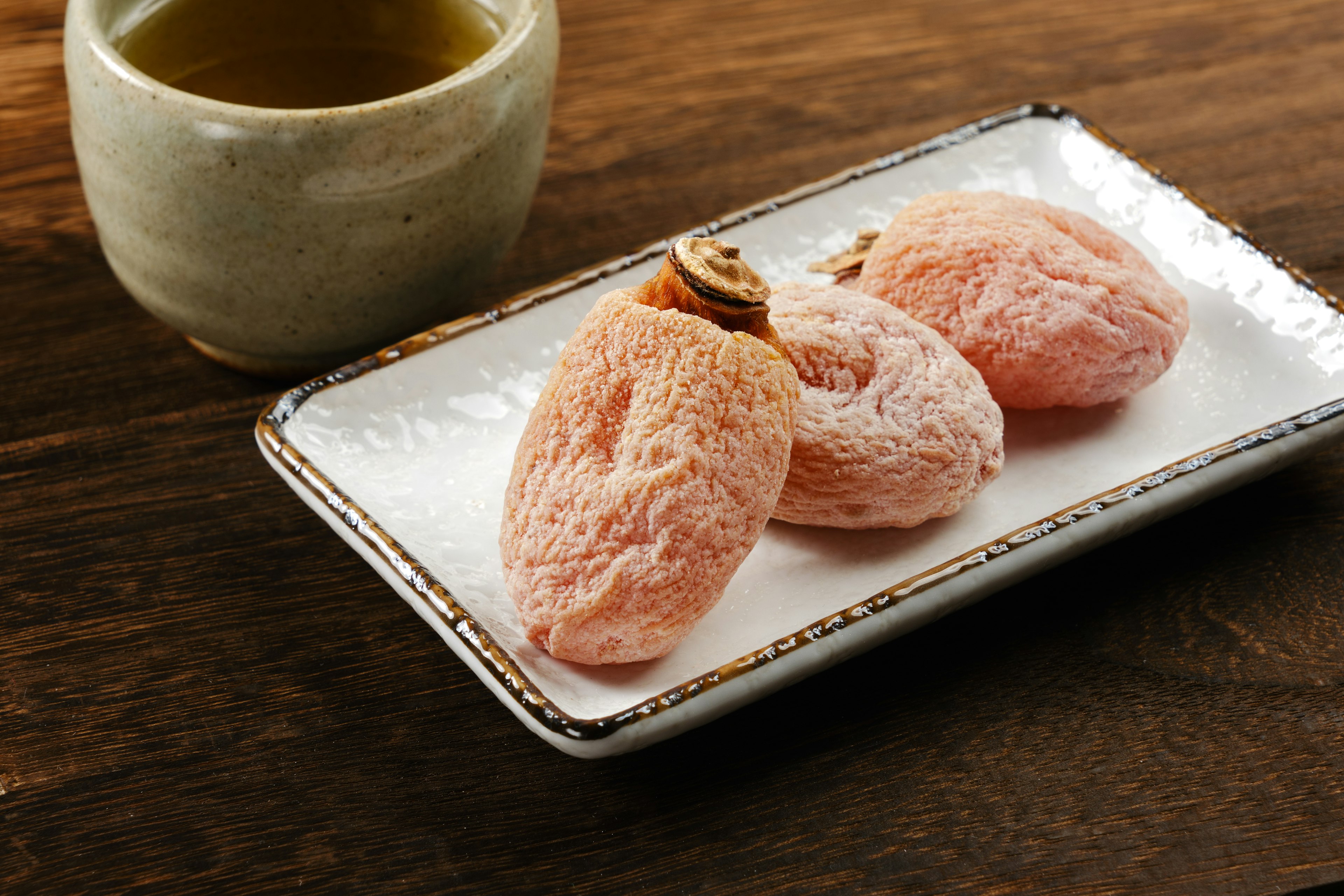 Teller mit Sakura-Mochi, serviert mit grünem Tee