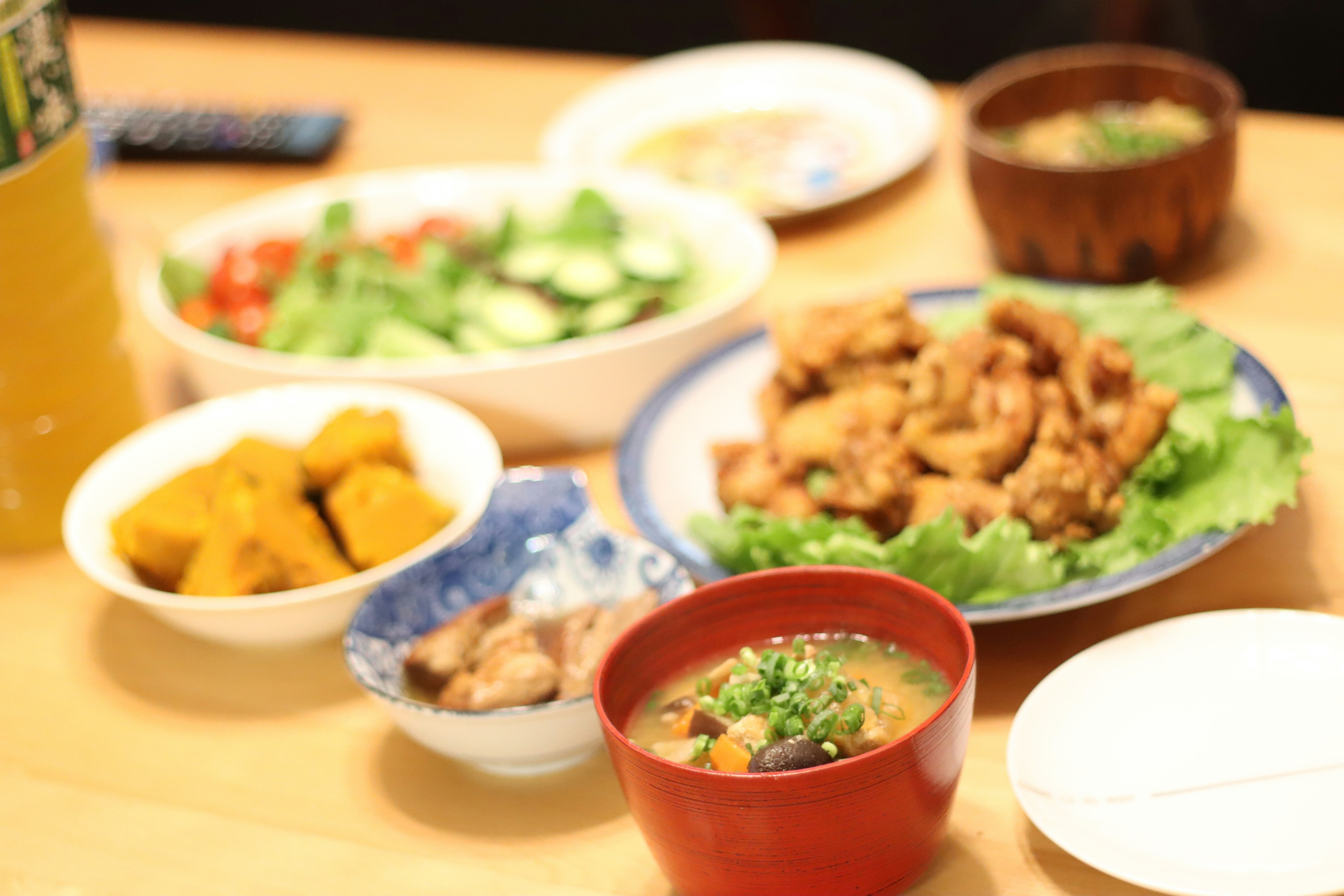 Ein buntes Arrangement japanischer Gerichte einschließlich gebratenem Hühnchen Salat Kürbis Eintopf Miso-Suppe