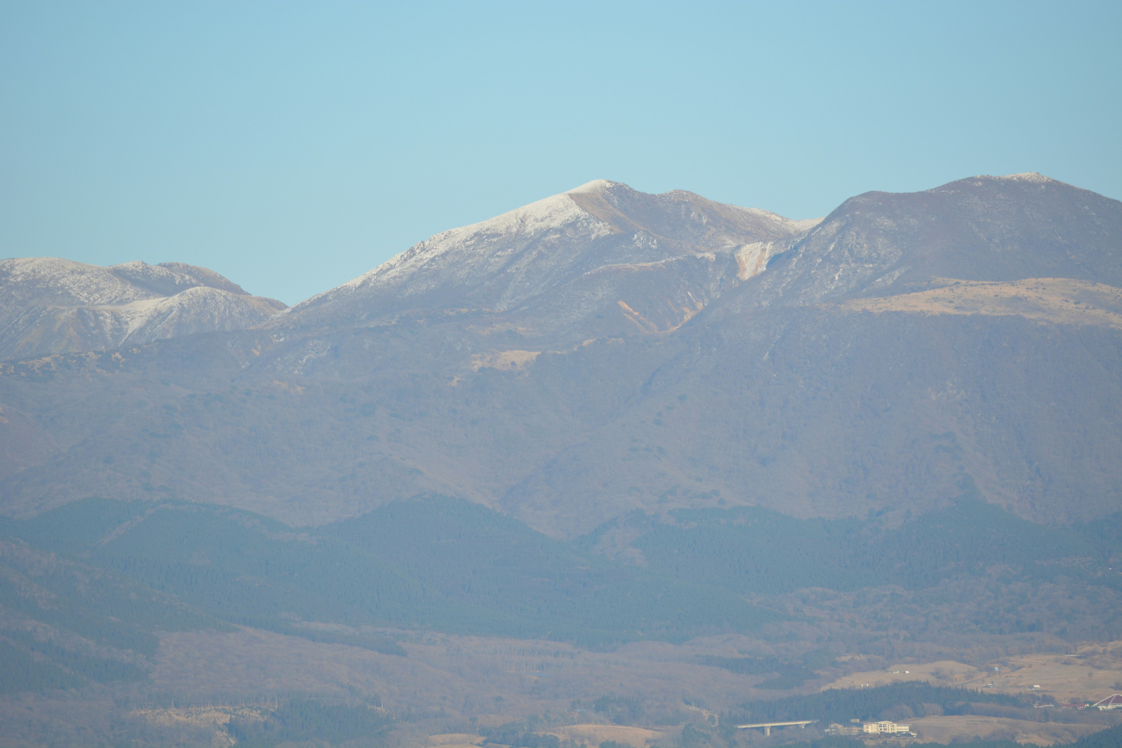 Paesaggio di montagne innevate sotto un cielo blu chiaro