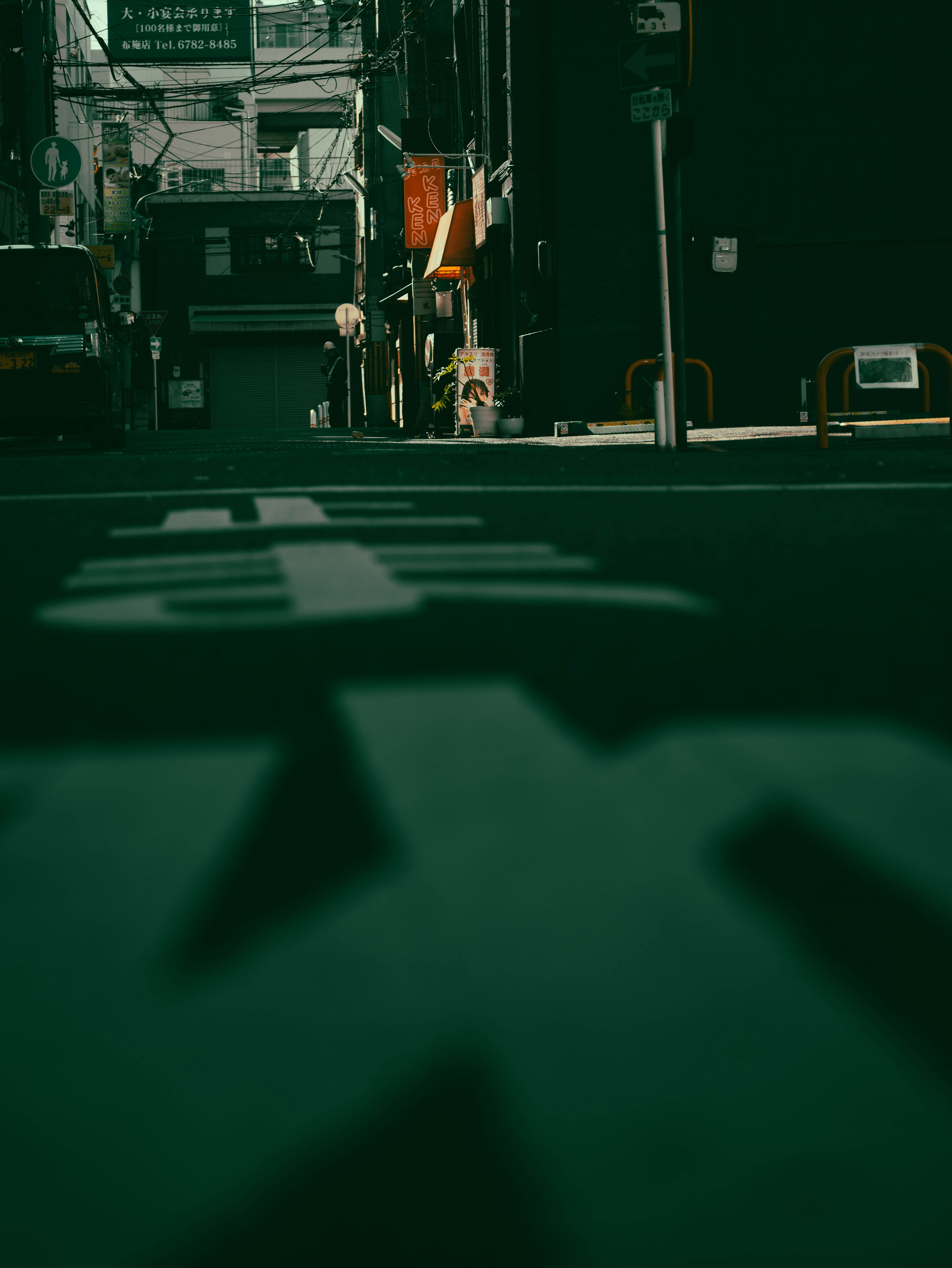 暗い路地の視点から撮影された街の風景に影が映る