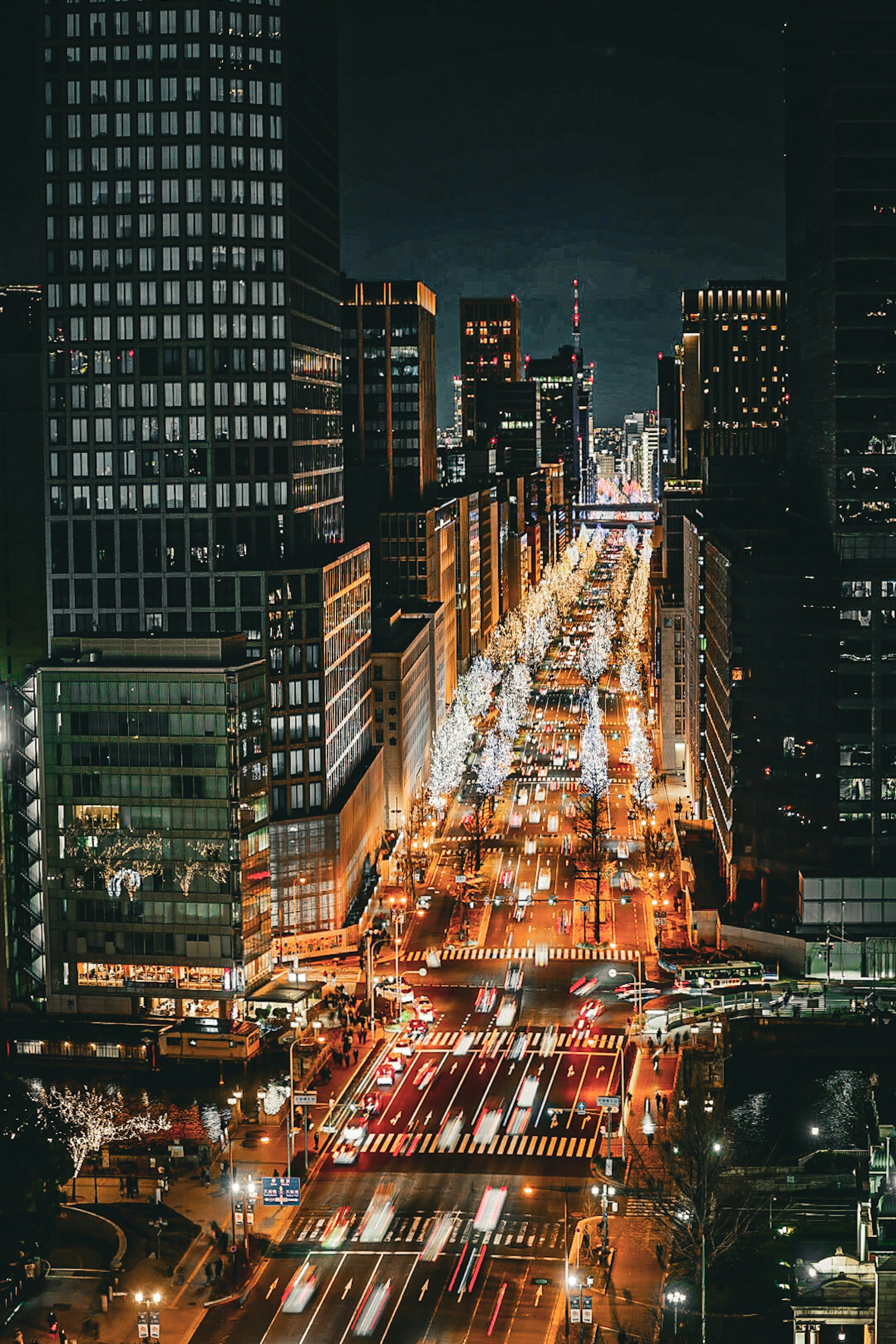 Aerial view of a cityscape at night featuring shimmering streetlights and car trails