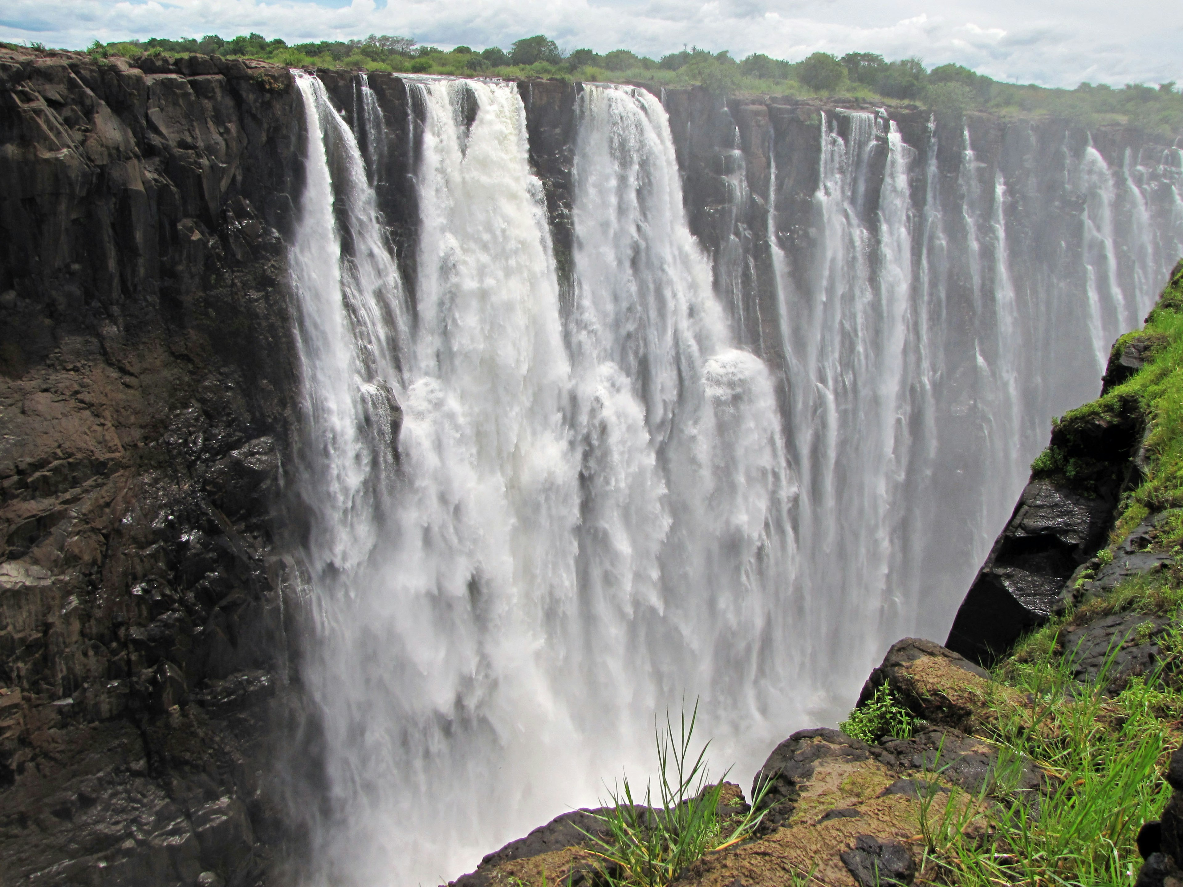 Majestic view of Victoria Falls surrounded by lush greenery and rocky cliffs