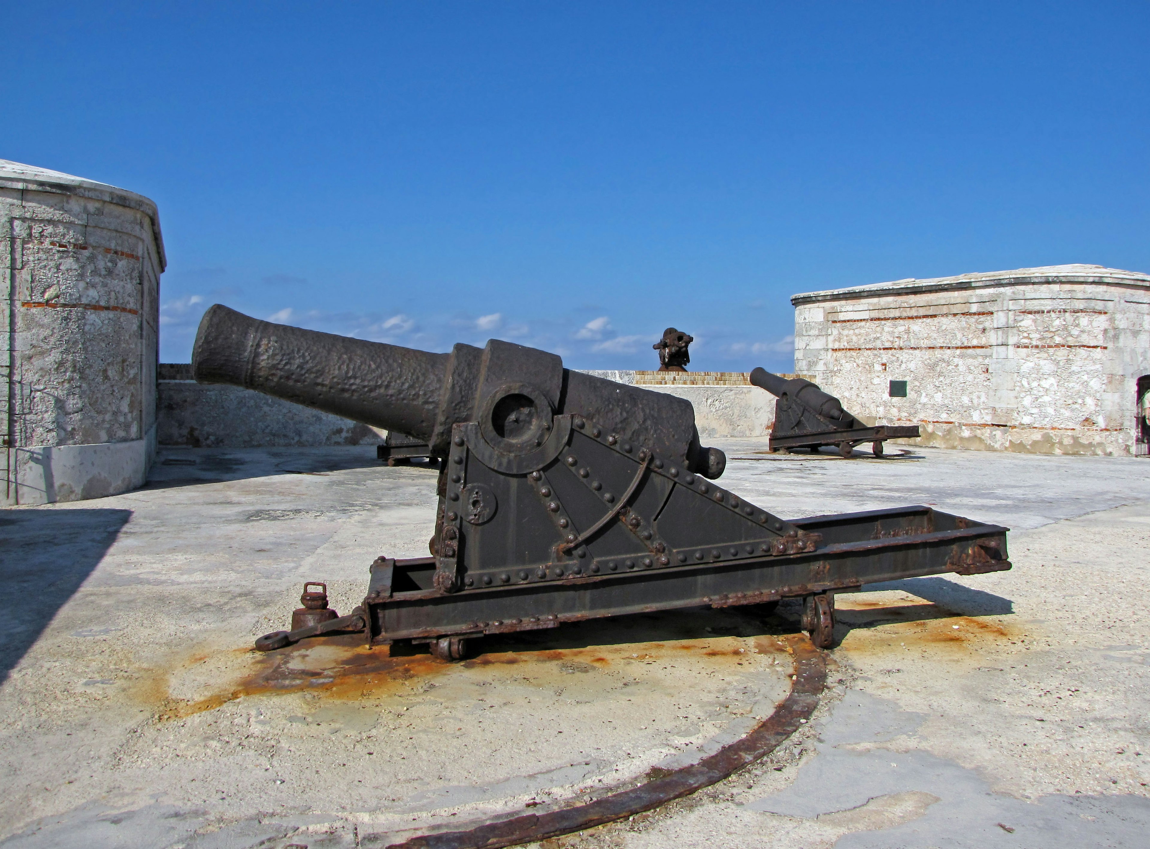 An old cannon on the rooftop of a fortress under a blue sky