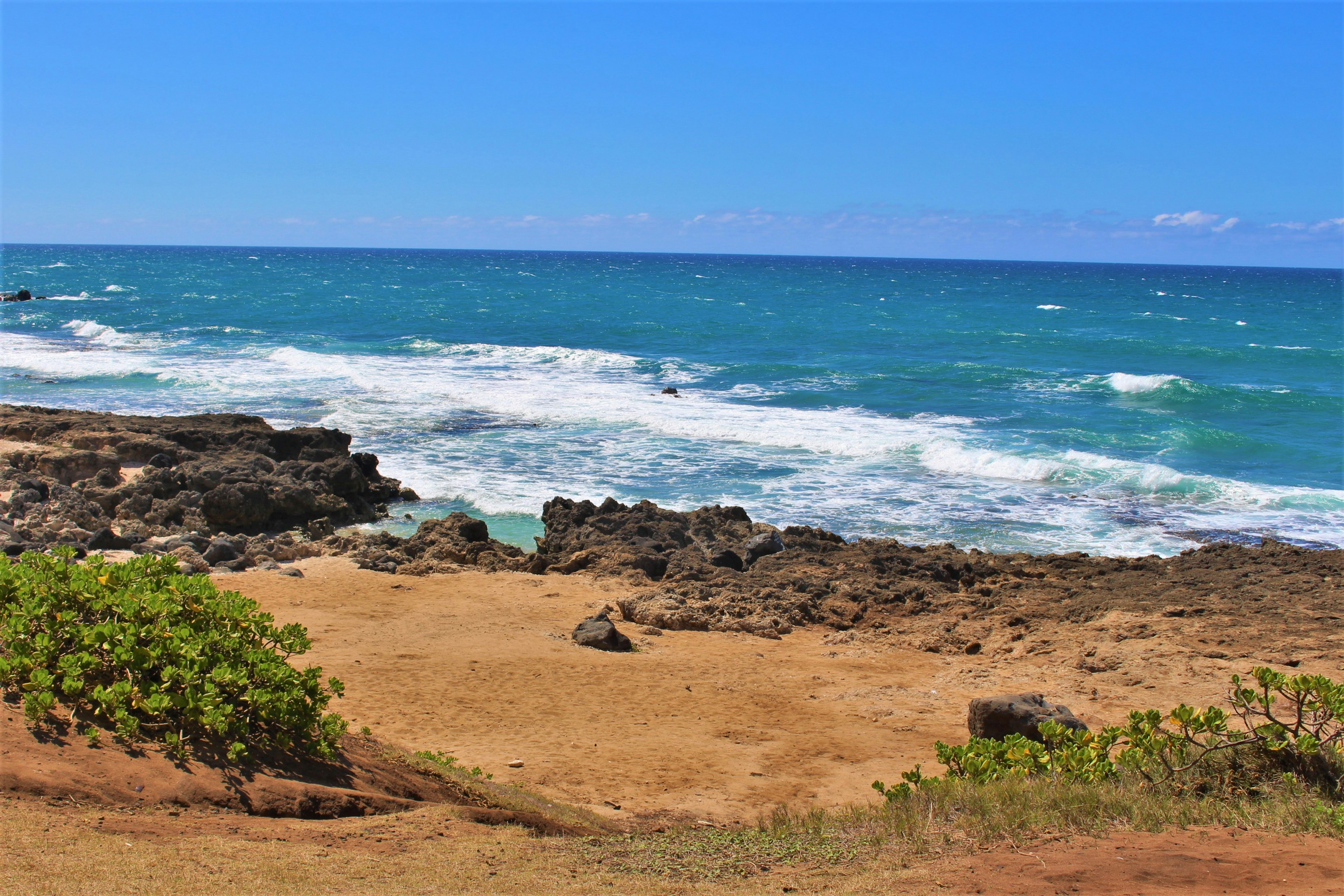 ทิวทัศน์ชายหาดพร้อมทะเลสีน้ำเงินและคลื่นสีขาว