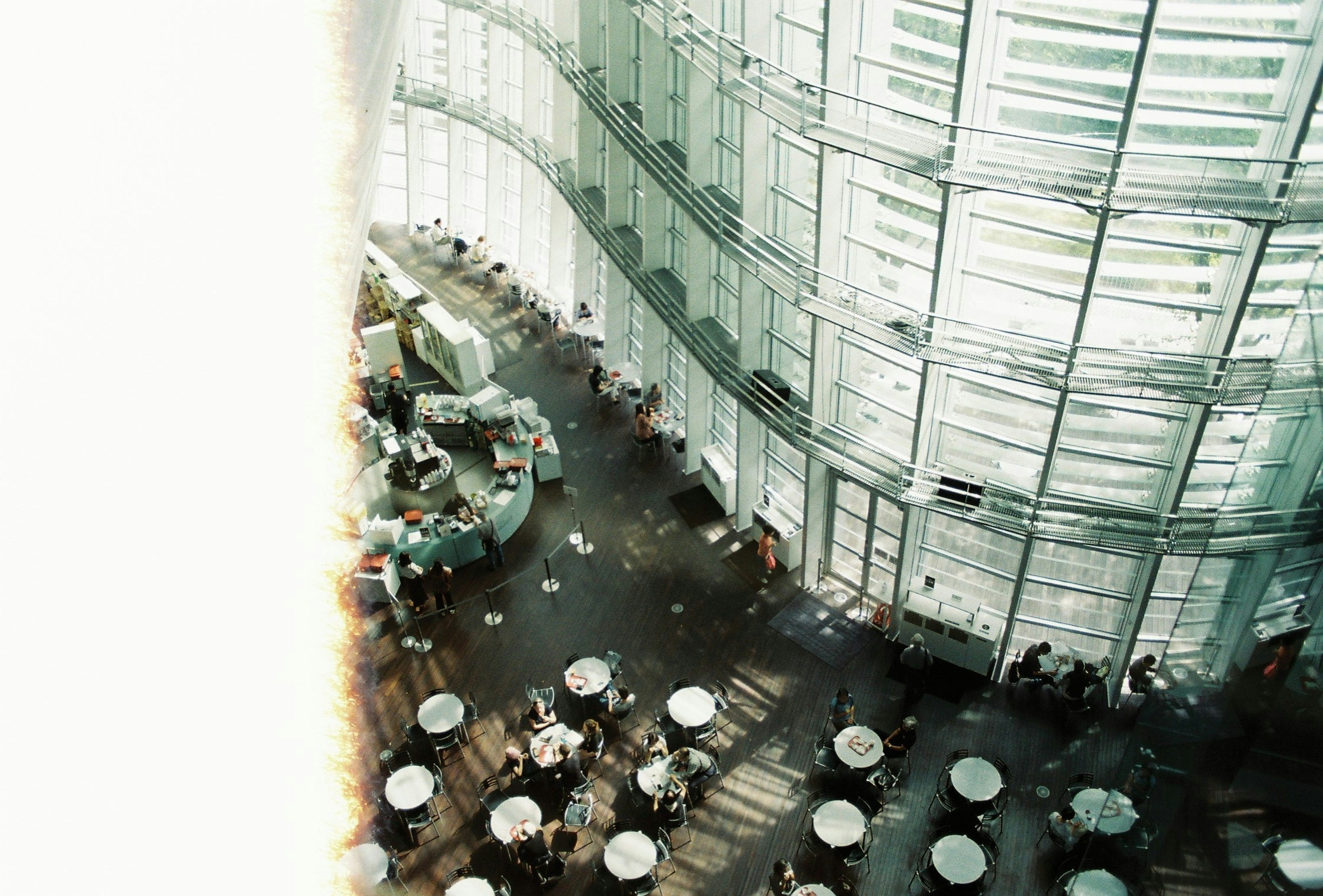 Interior de una cafetería moderna con mesas y diseño curvado