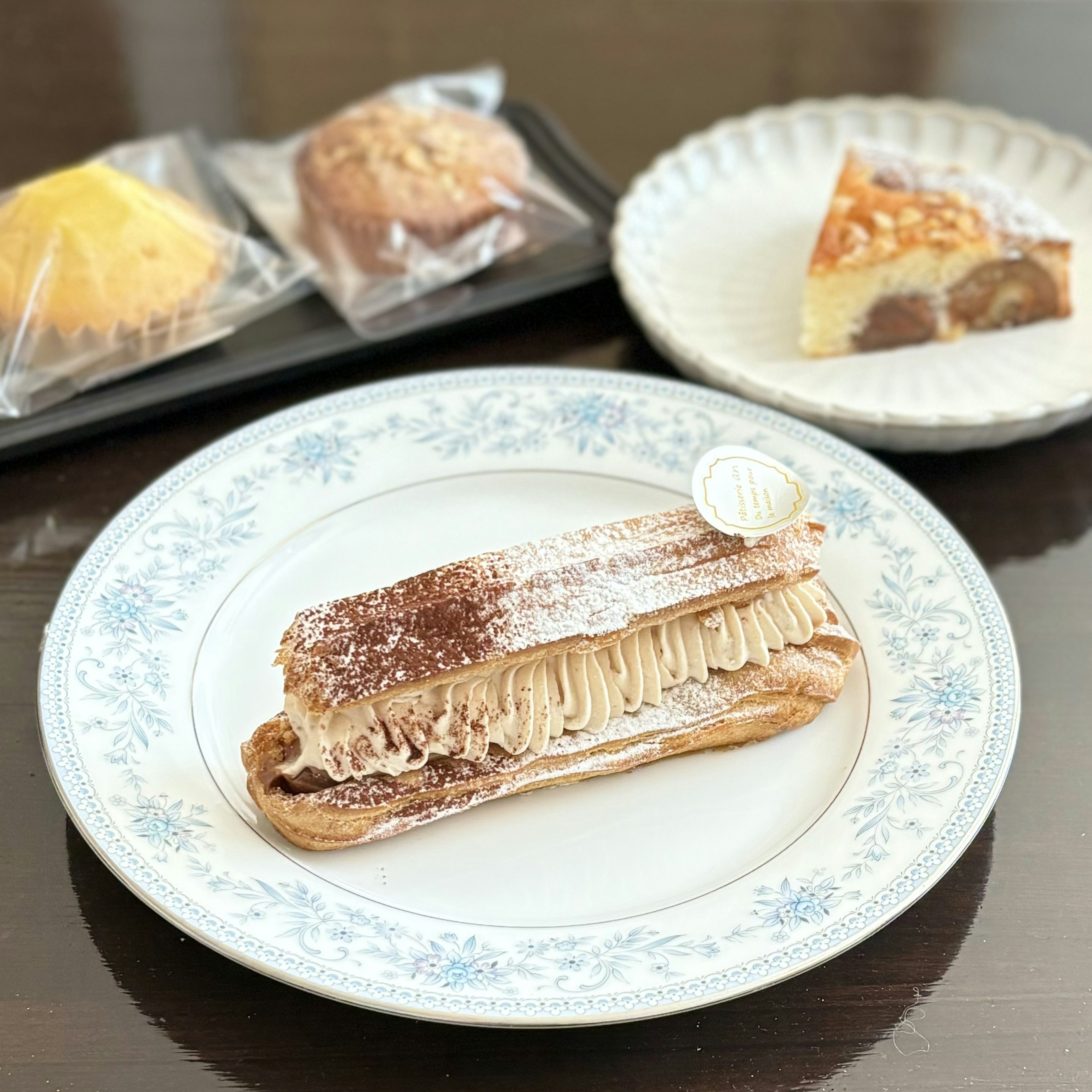 Charming dessert display featuring a Mont Blanc eclair on a decorative plate alongside assorted pastries