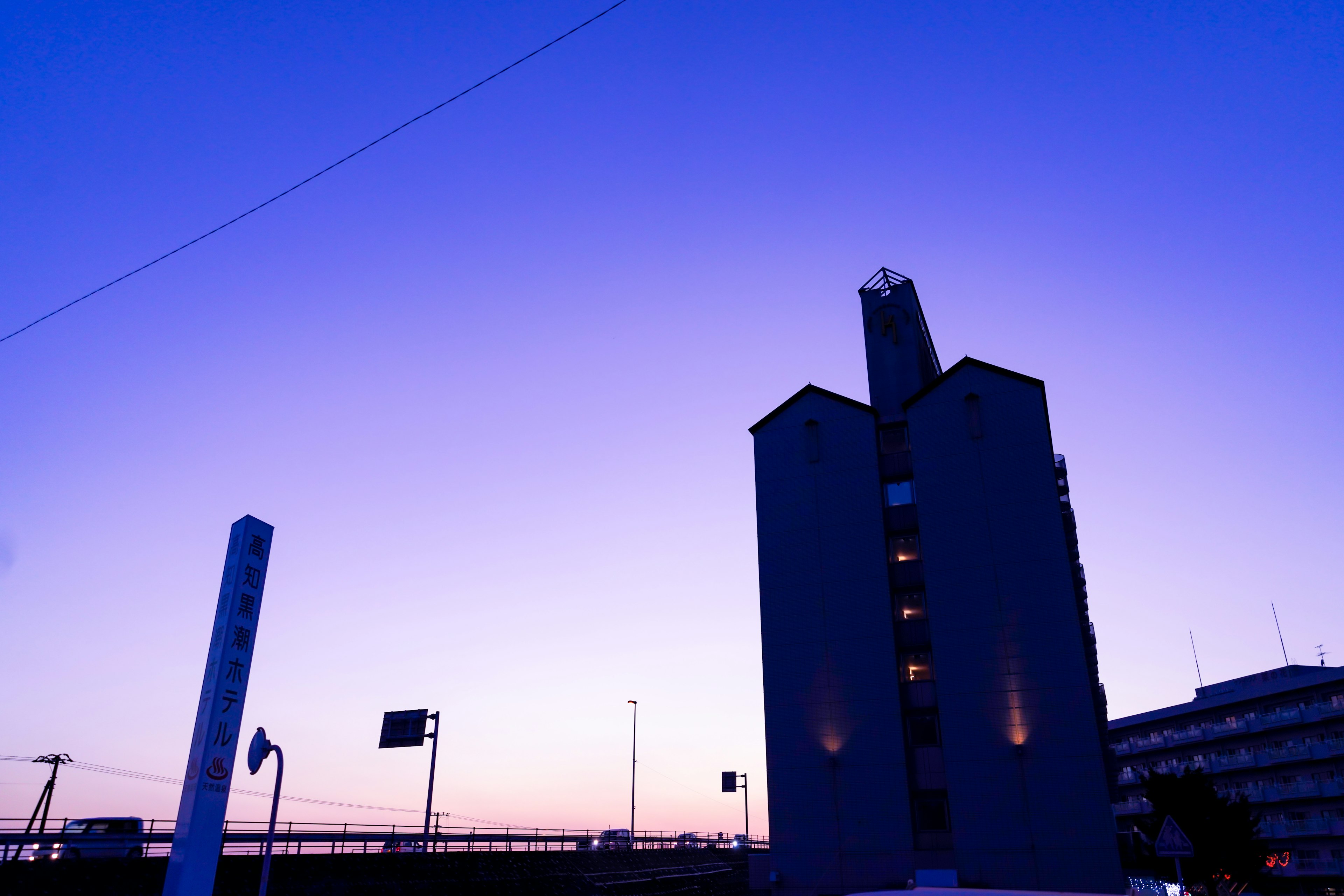 夕暮れの青紫色の空に silhouetted な建物が立っている