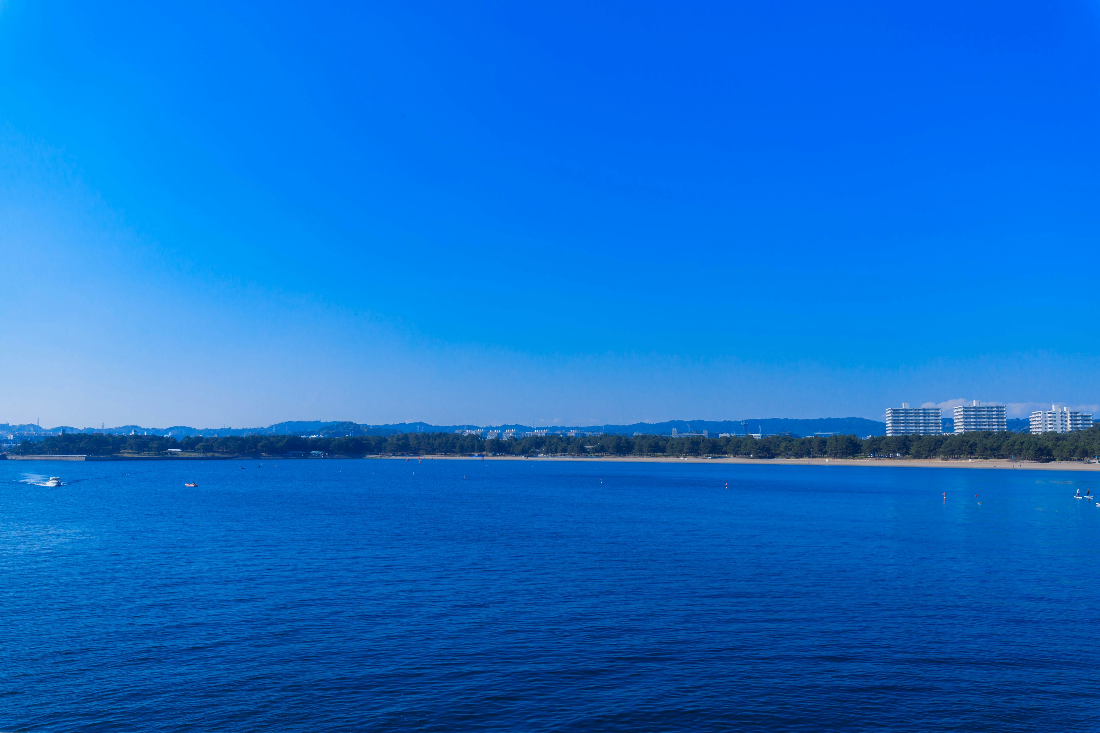 Vista panorámica del océano azul y el cielo con playa y edificios