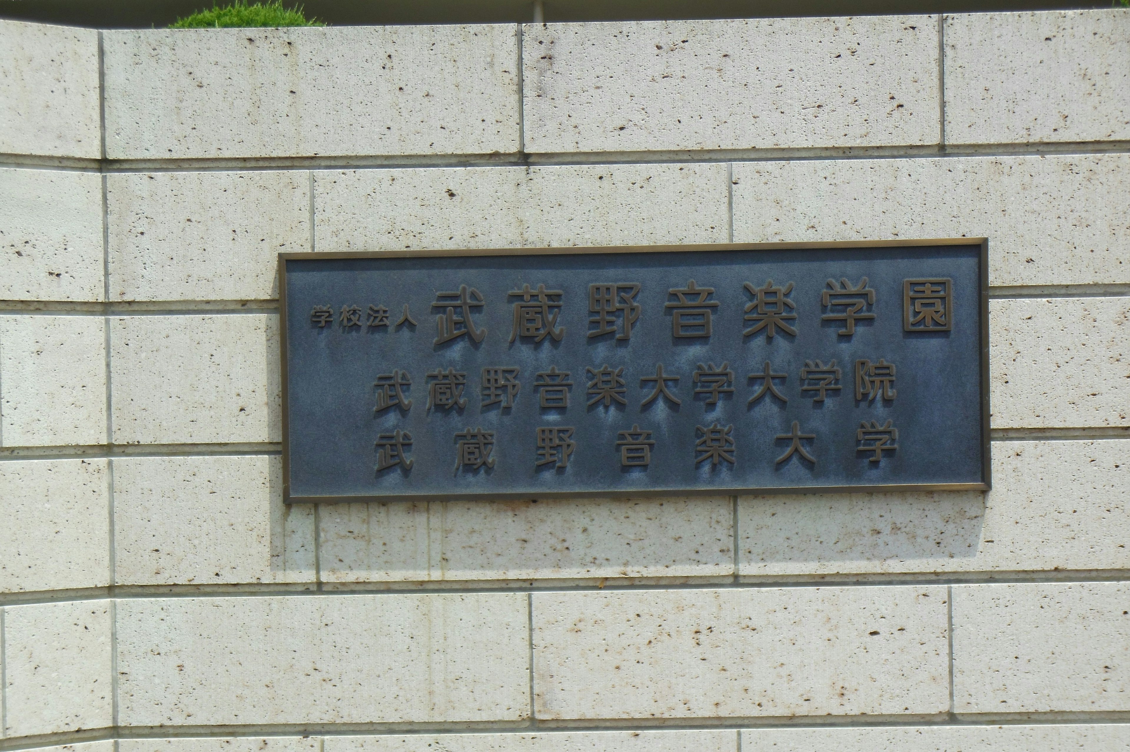 Cartel de un museo en la ciudad de Kanazawa montado en una pared de piedra