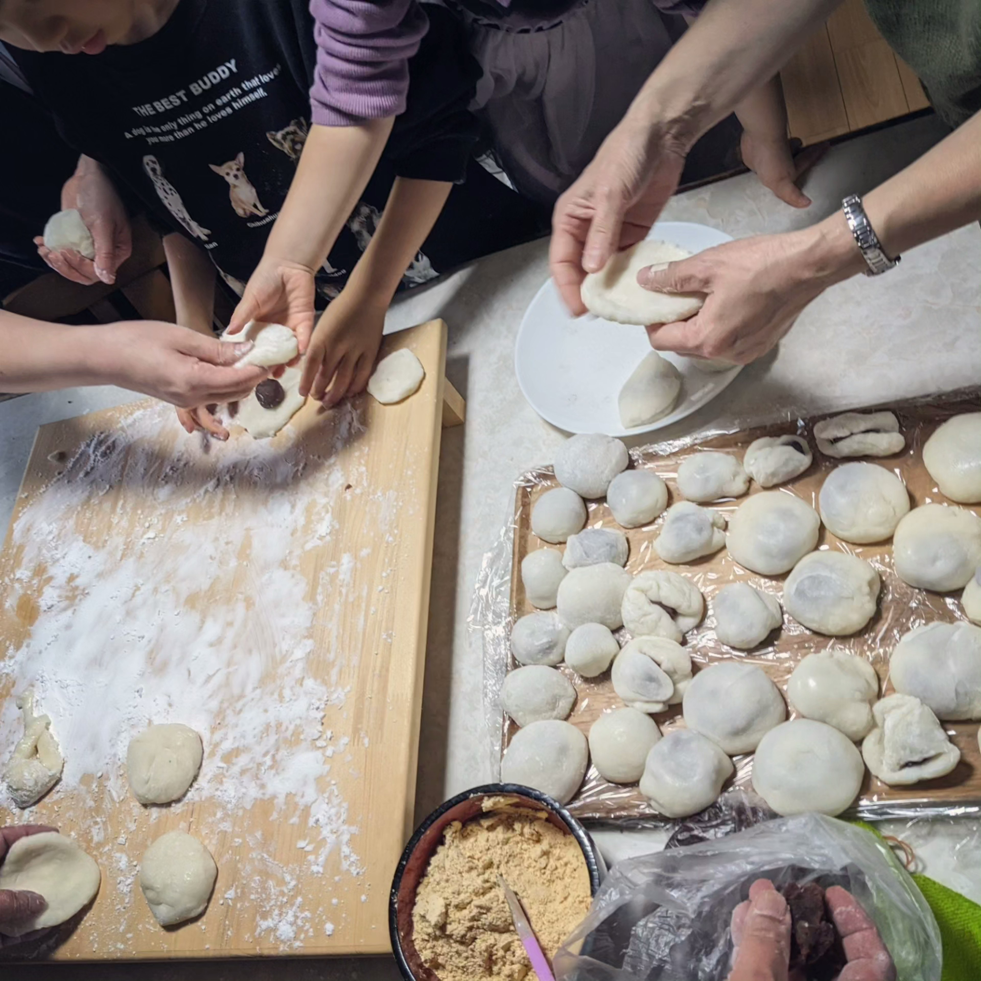 Một gia đình đang làm bánh bao cùng nhau Bàn tay của trẻ em và người lớn đang định hình bột