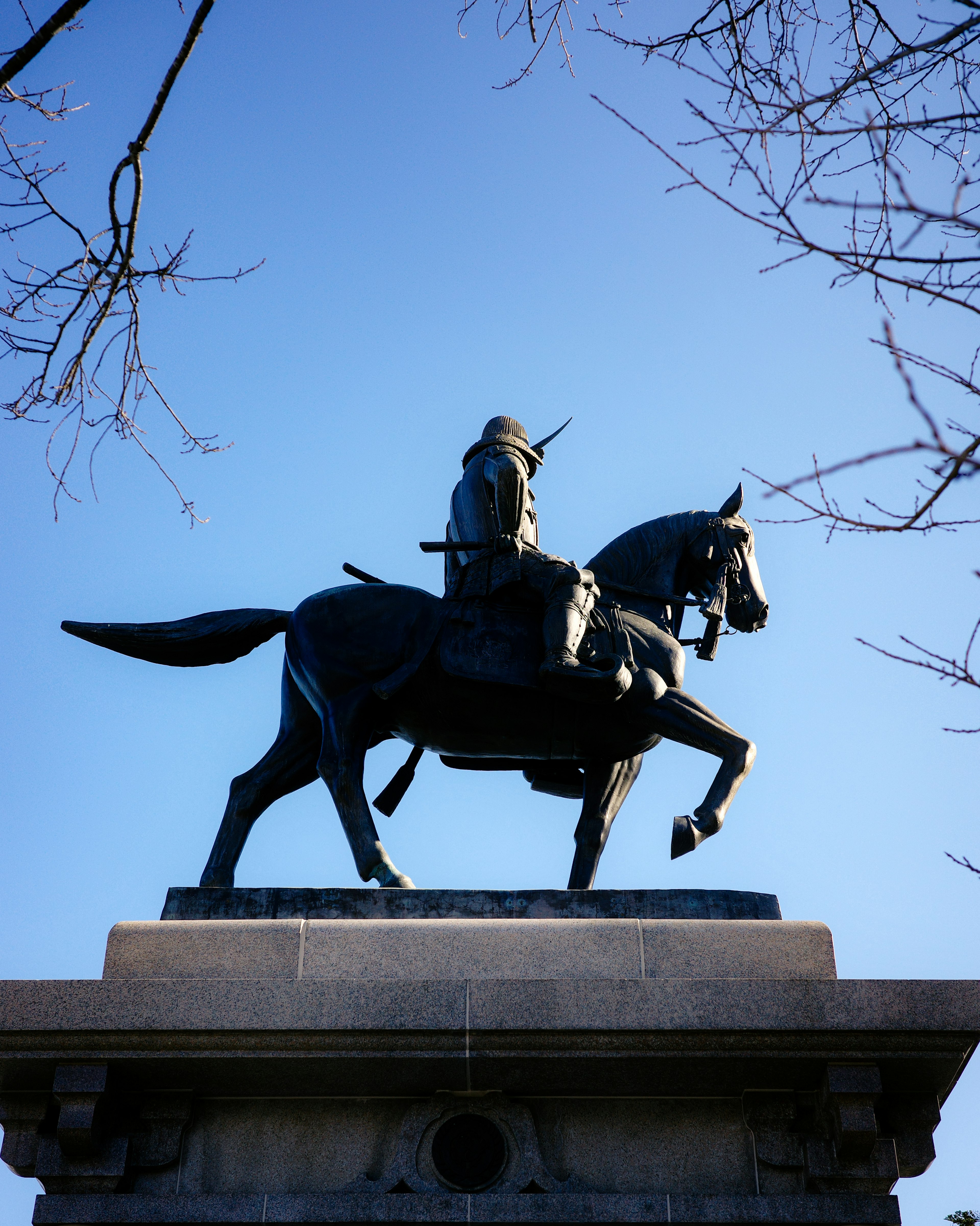 Eine Bronzestatue eines Ritters zu Pferd vor blauem Himmel