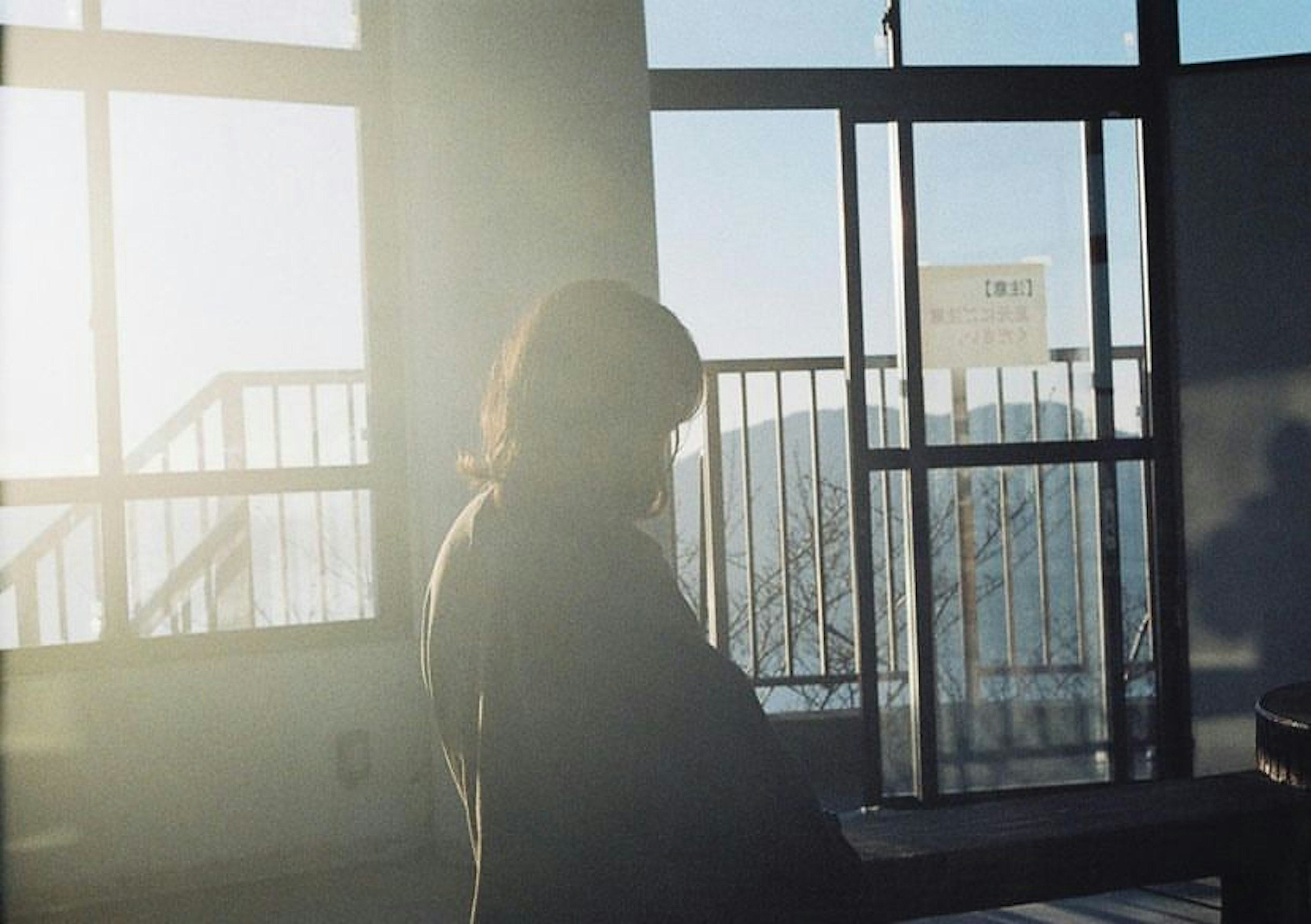 Silhouette of a woman standing by a window with soft backlight