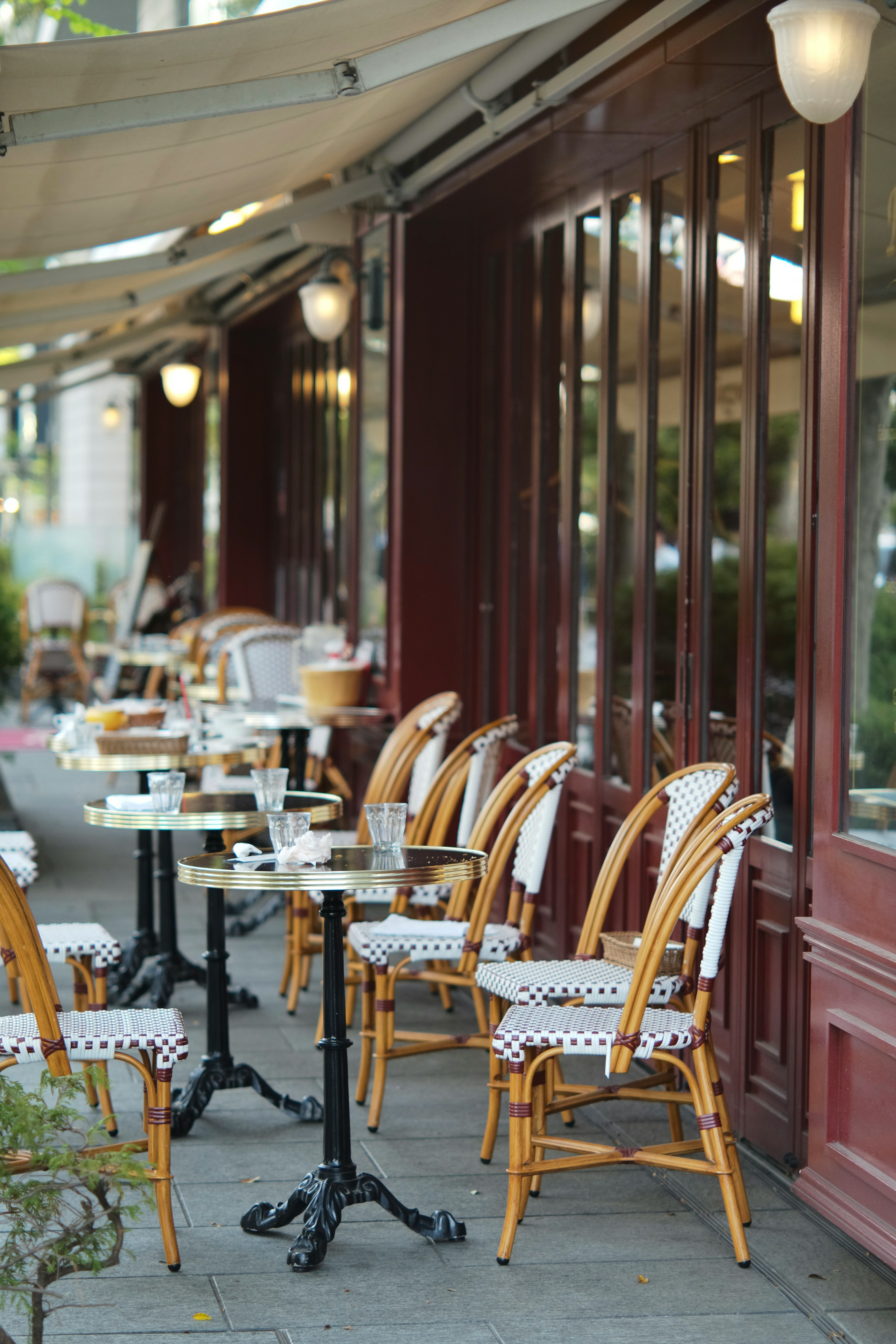 Chaises et tables en bois alignées sur une terrasse de café