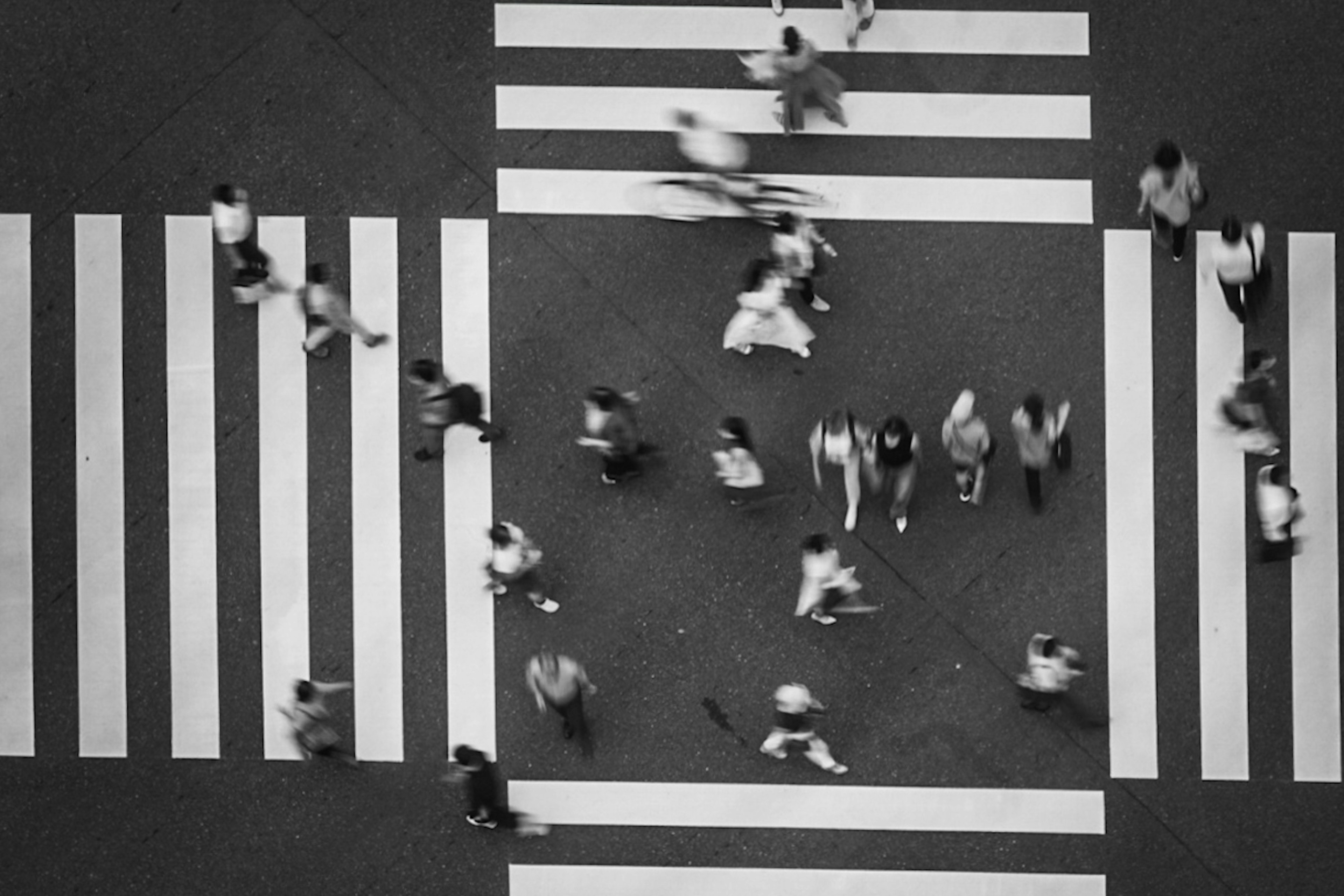 人々が交差点を渡る白黒の写真