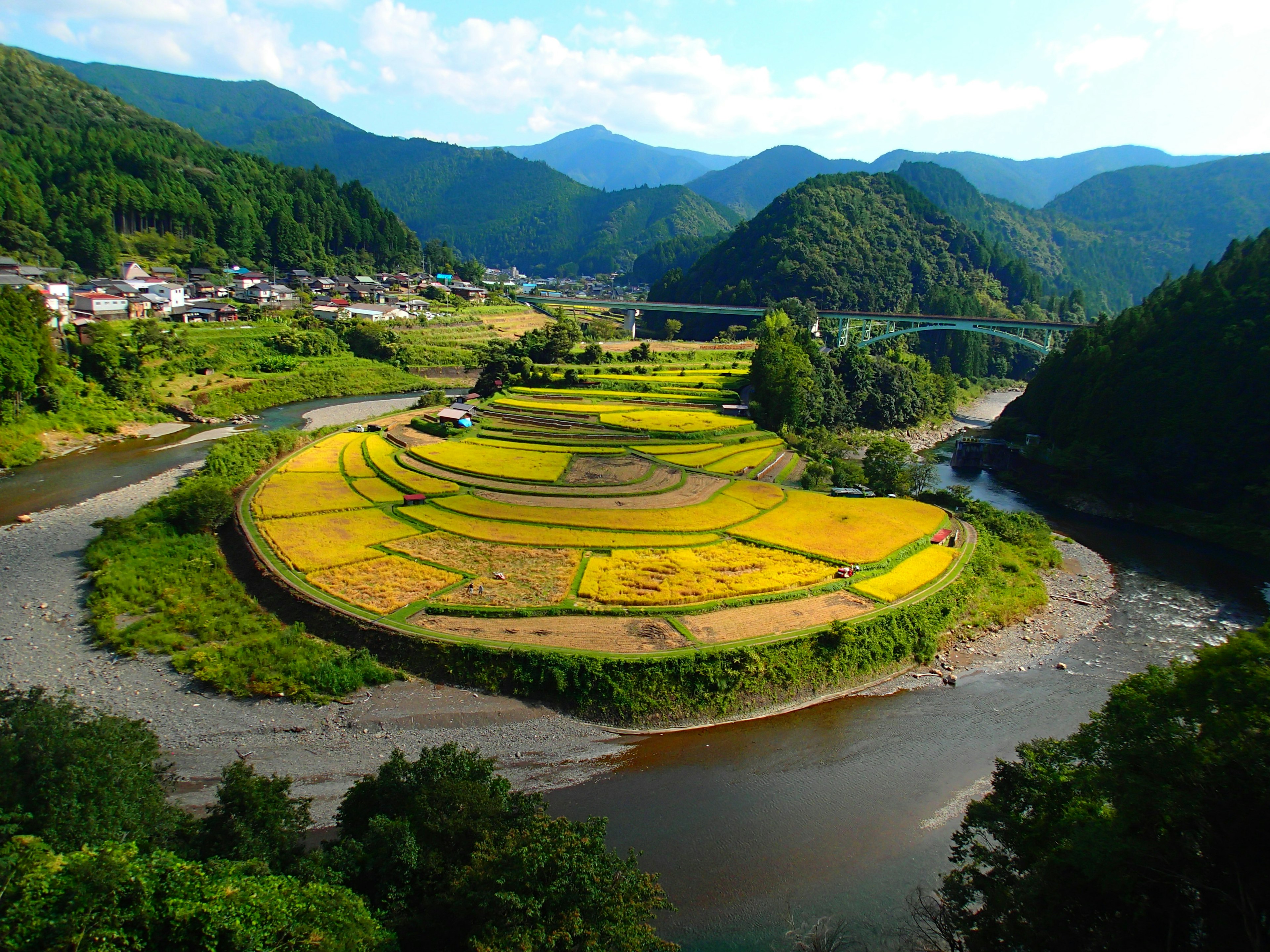 美しい山々に囲まれた田んぼの風景と川の流れ