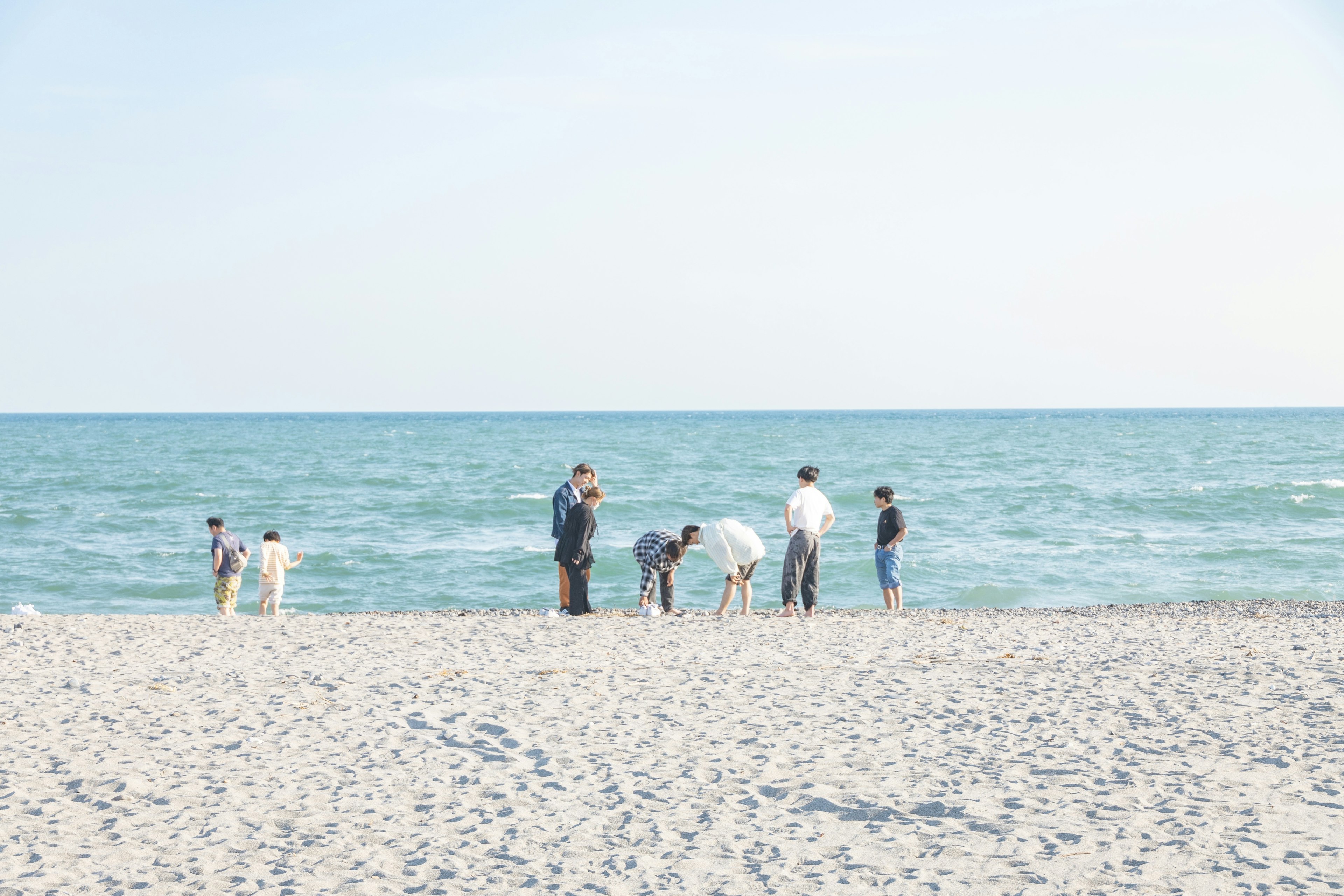 People playing on the beach with blue ocean