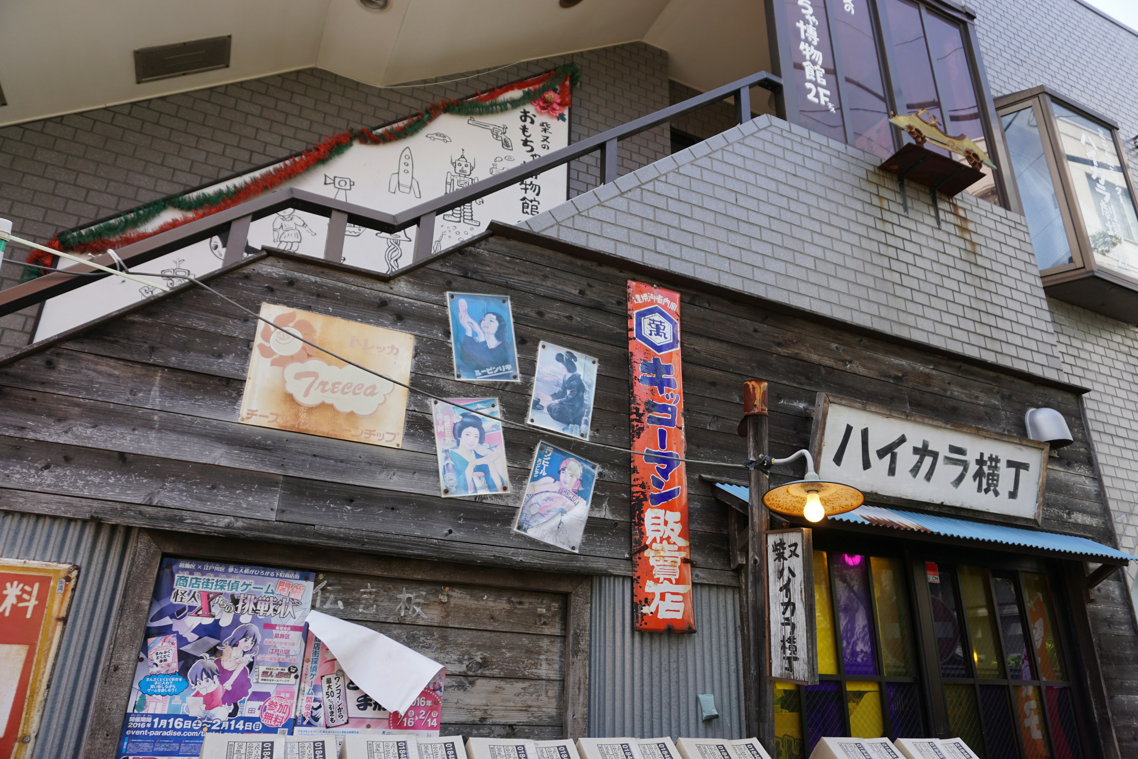 Exterior of a Japanese commercial building featuring posters on a wooden wall