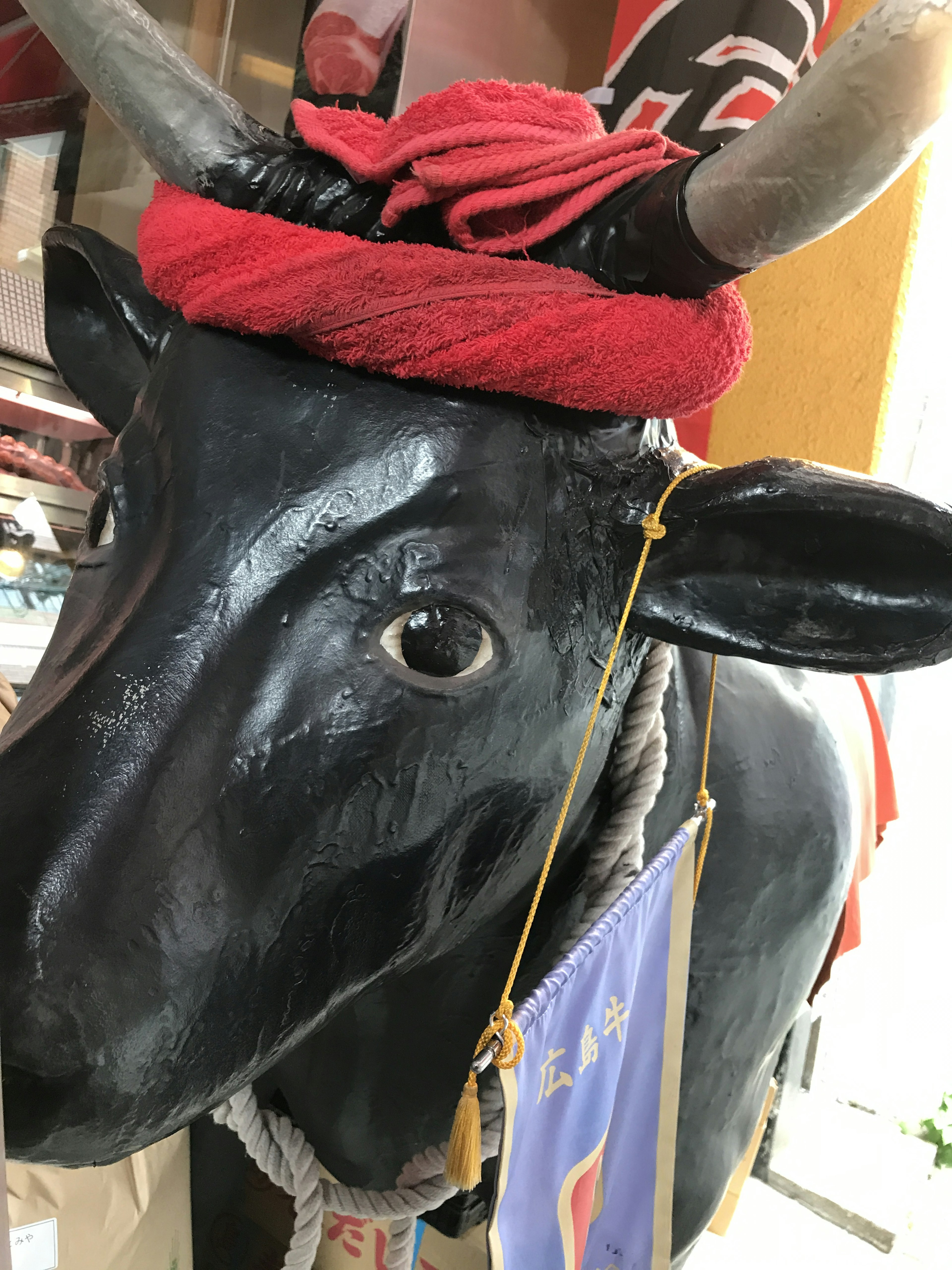 Black cow head decorated with a red cloth and a flag