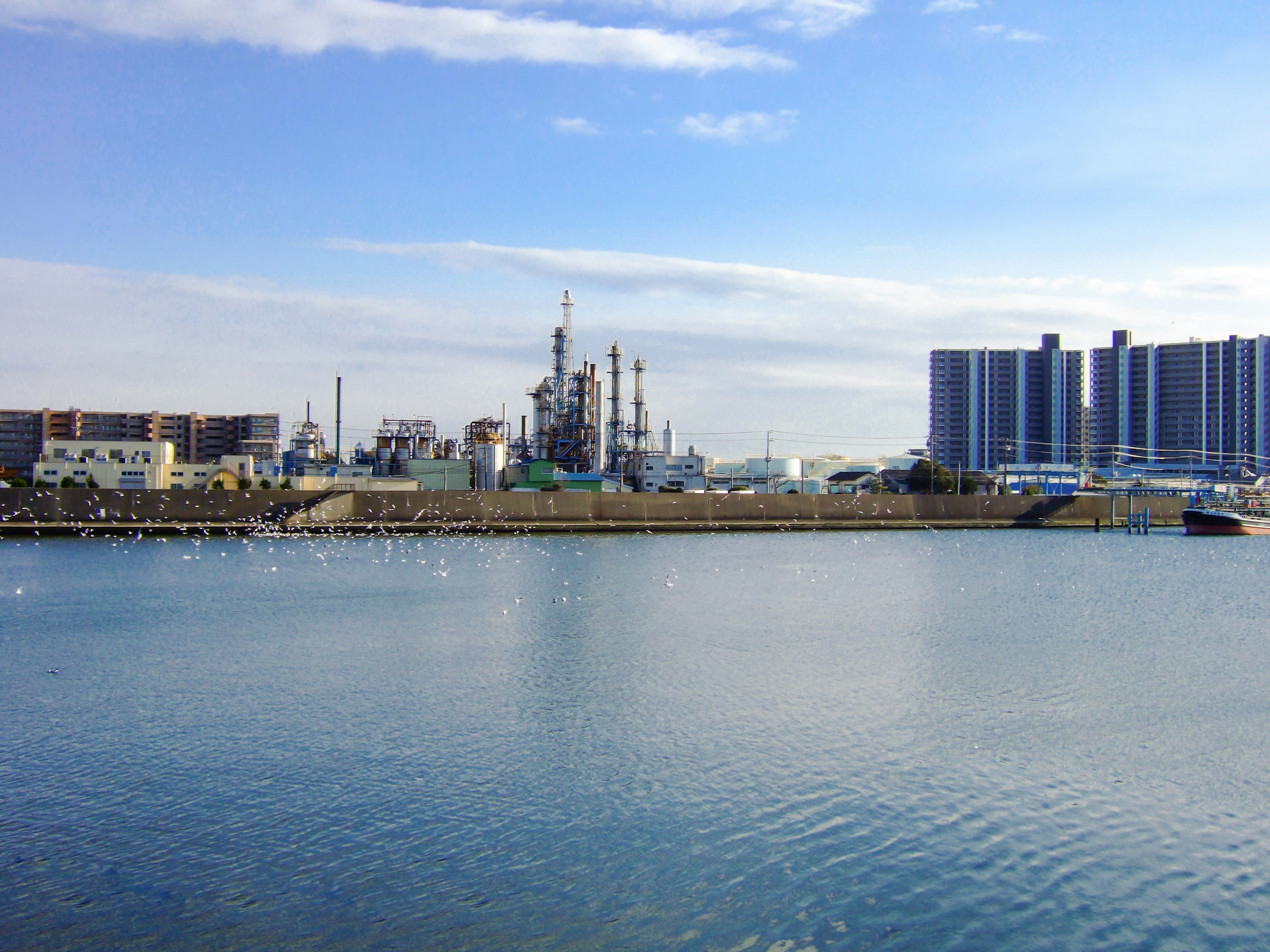 Paysage industriel avec des usines et de l'eau calme ciel bleu