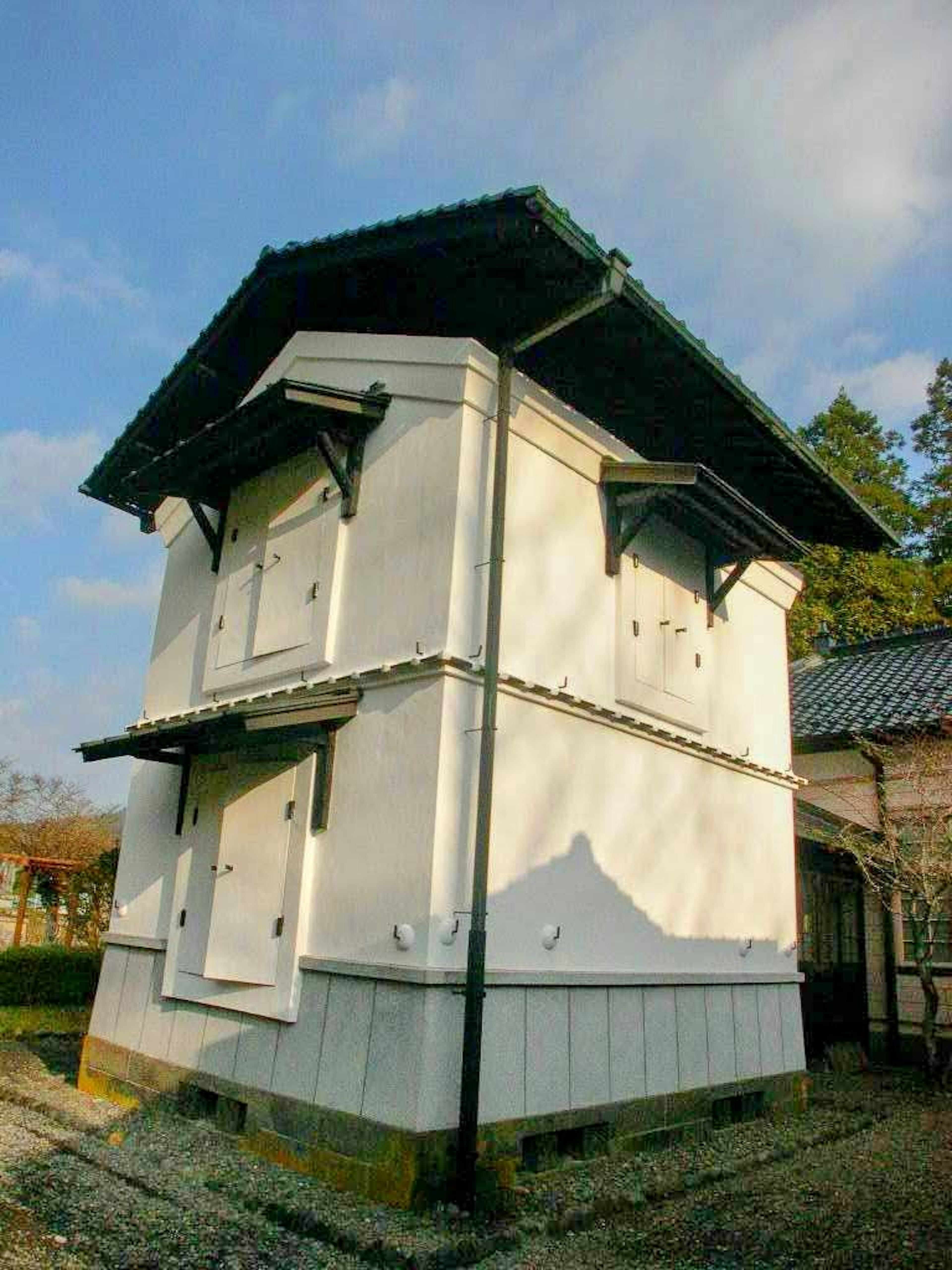 Two-story building with white walls and a black roof