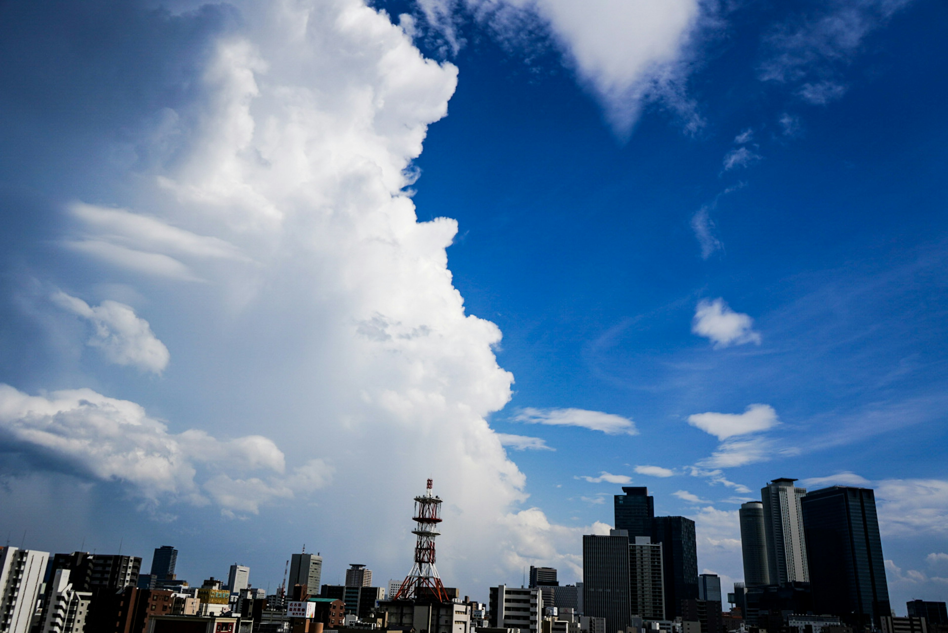 Skyline di città con nuvole drammatiche e cielo blu