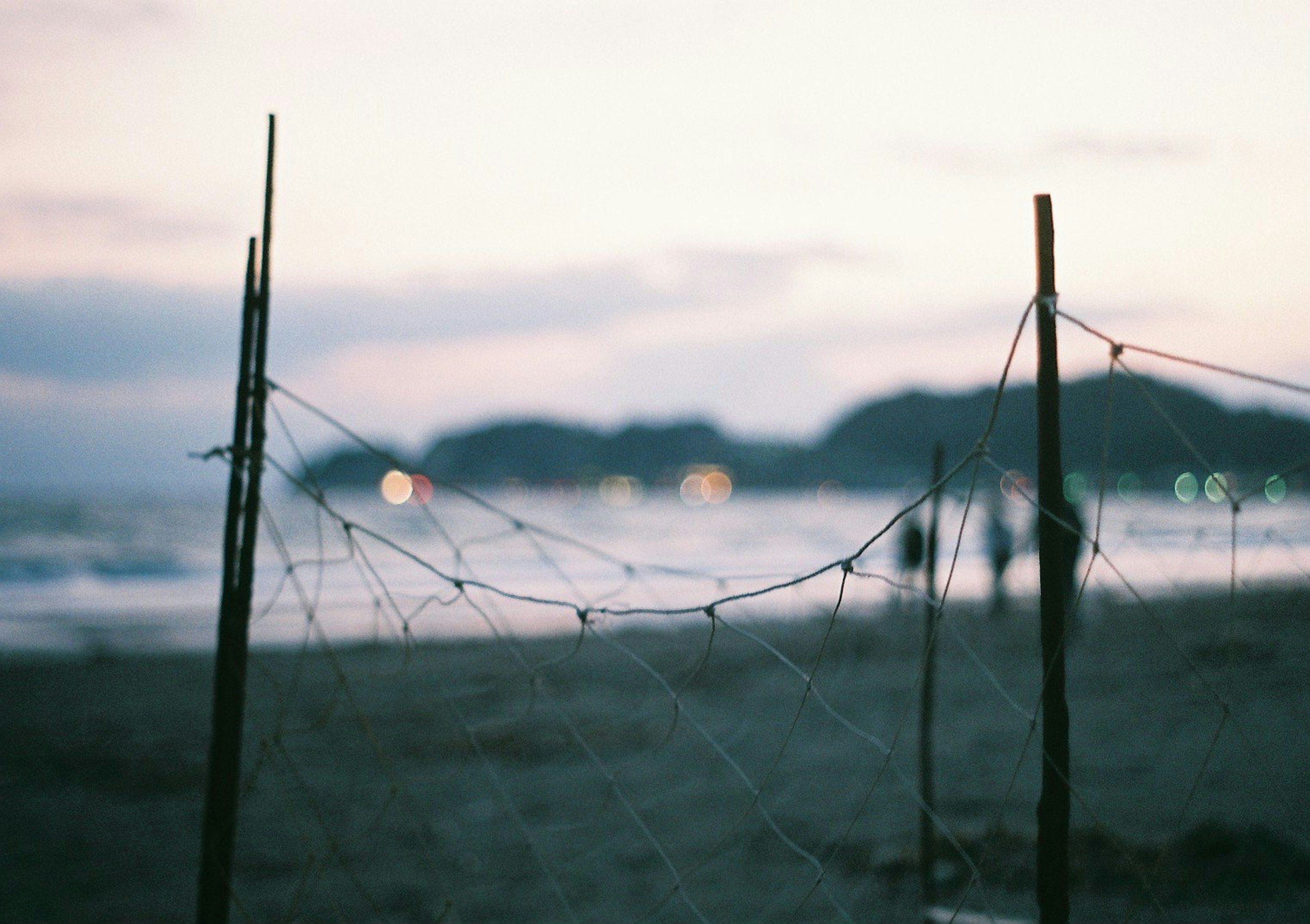 Beach scene featuring a fishing net structure and blurred background