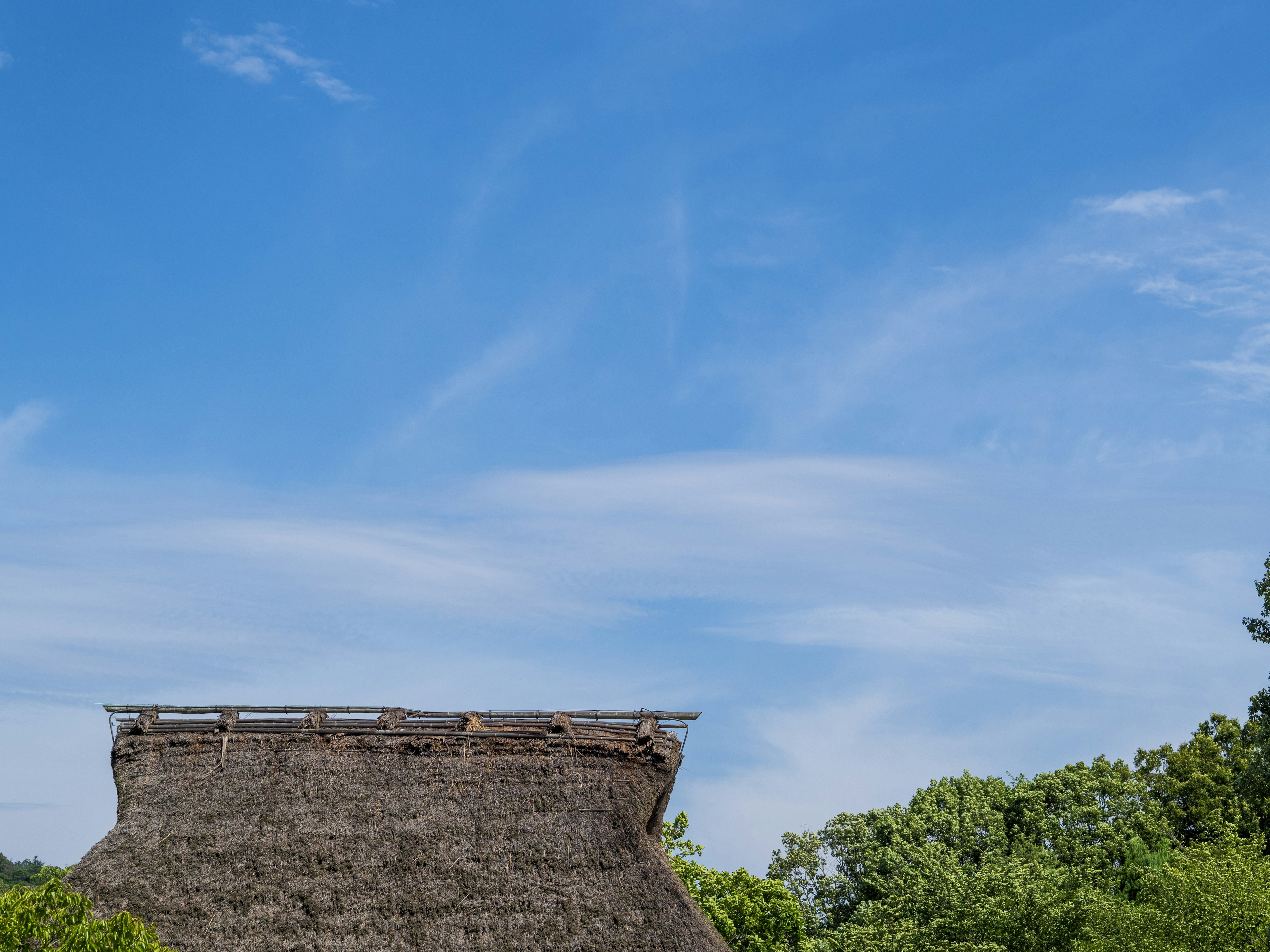 Bâtiment traditionnel au toit de chaume sous un ciel bleu