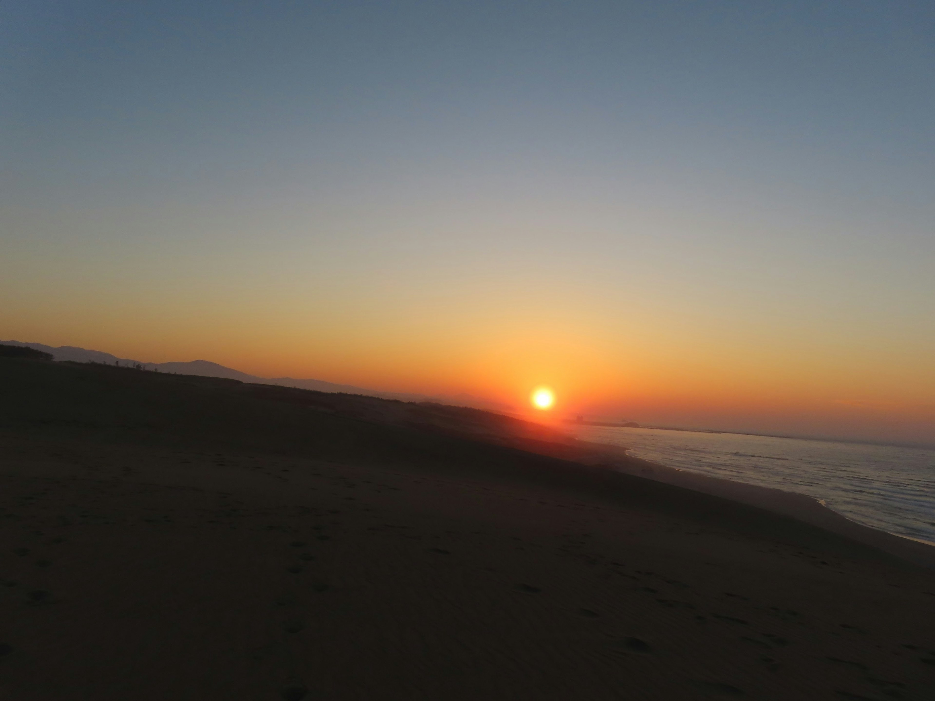 Sunset over the coastline with calm sea