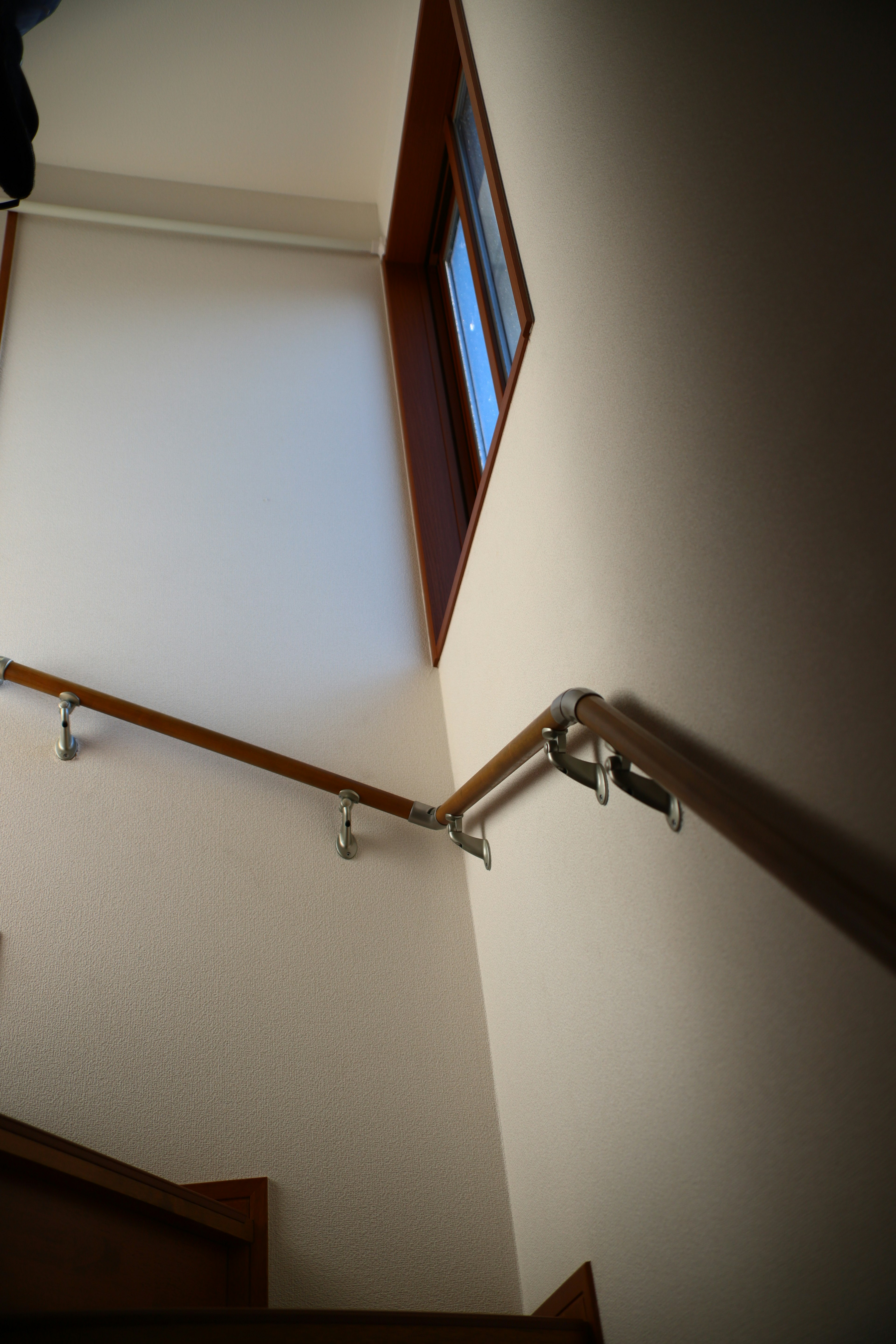 Image showing a staircase with a handrail and a corner wall natural light coming from a window