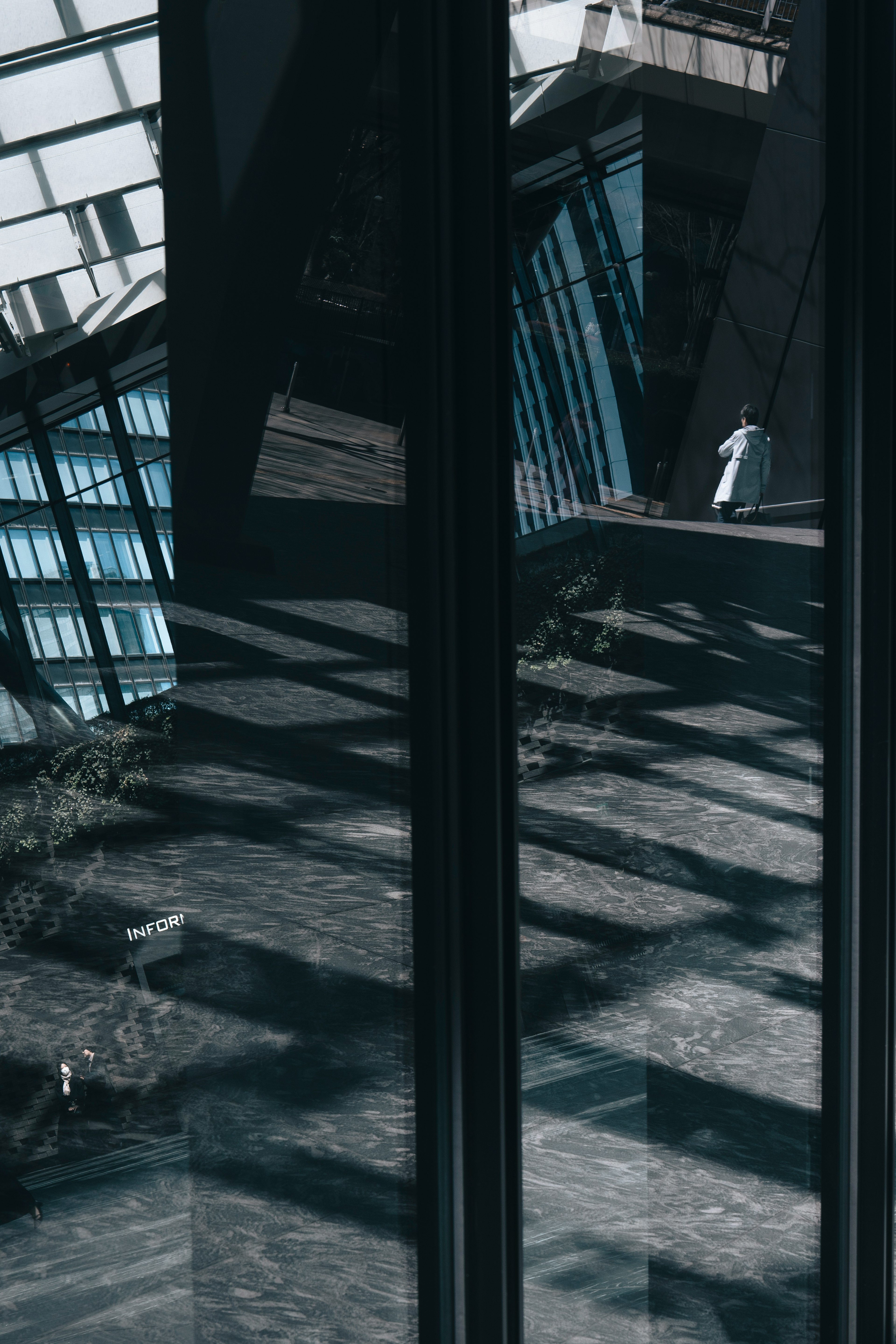 Reflection of a modern building and a person in glass