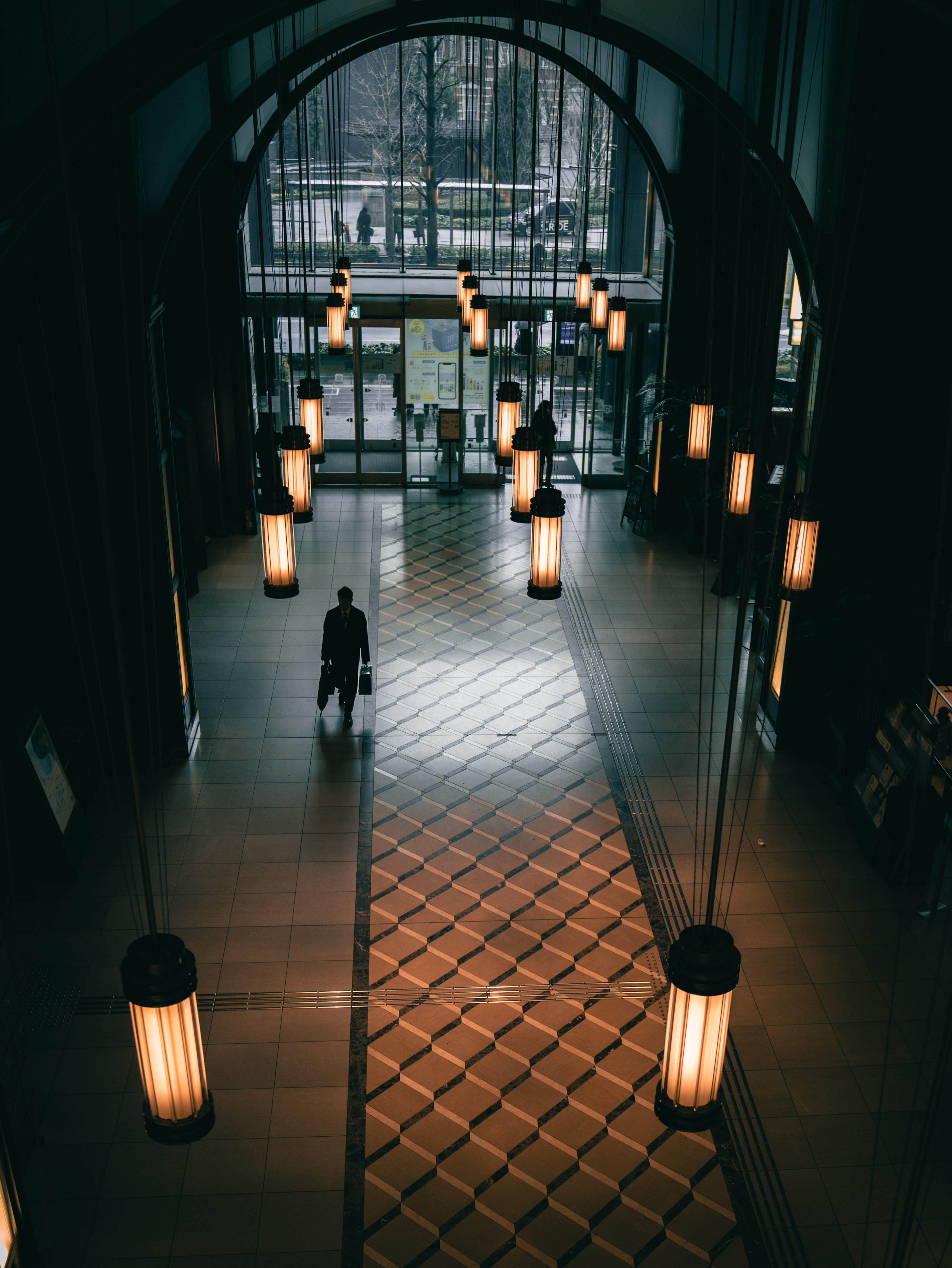 Spacious lobby with arch ceiling featuring hanging lamps and tiled floor