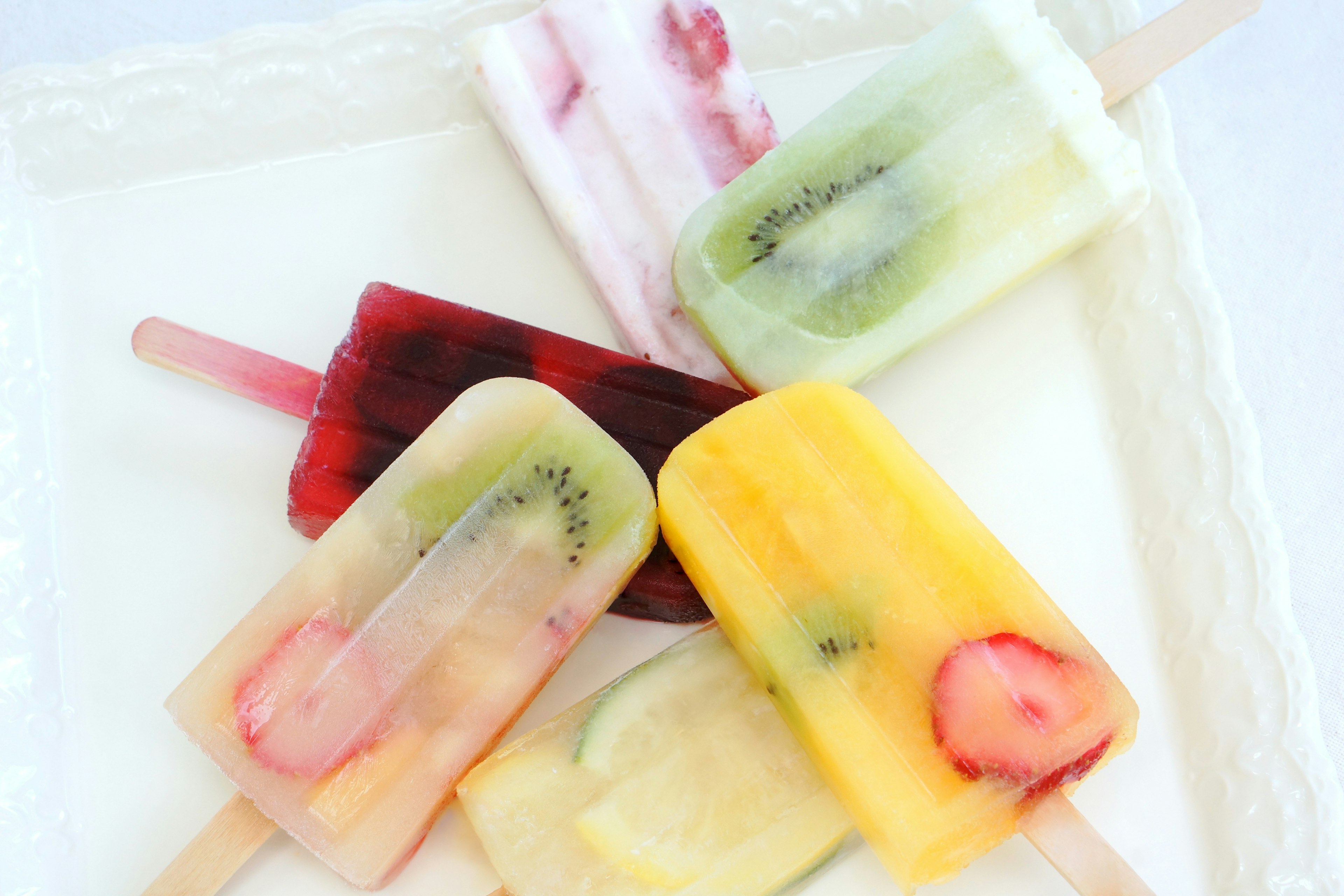 Popsicles colorés aux fruits disposés sur une assiette